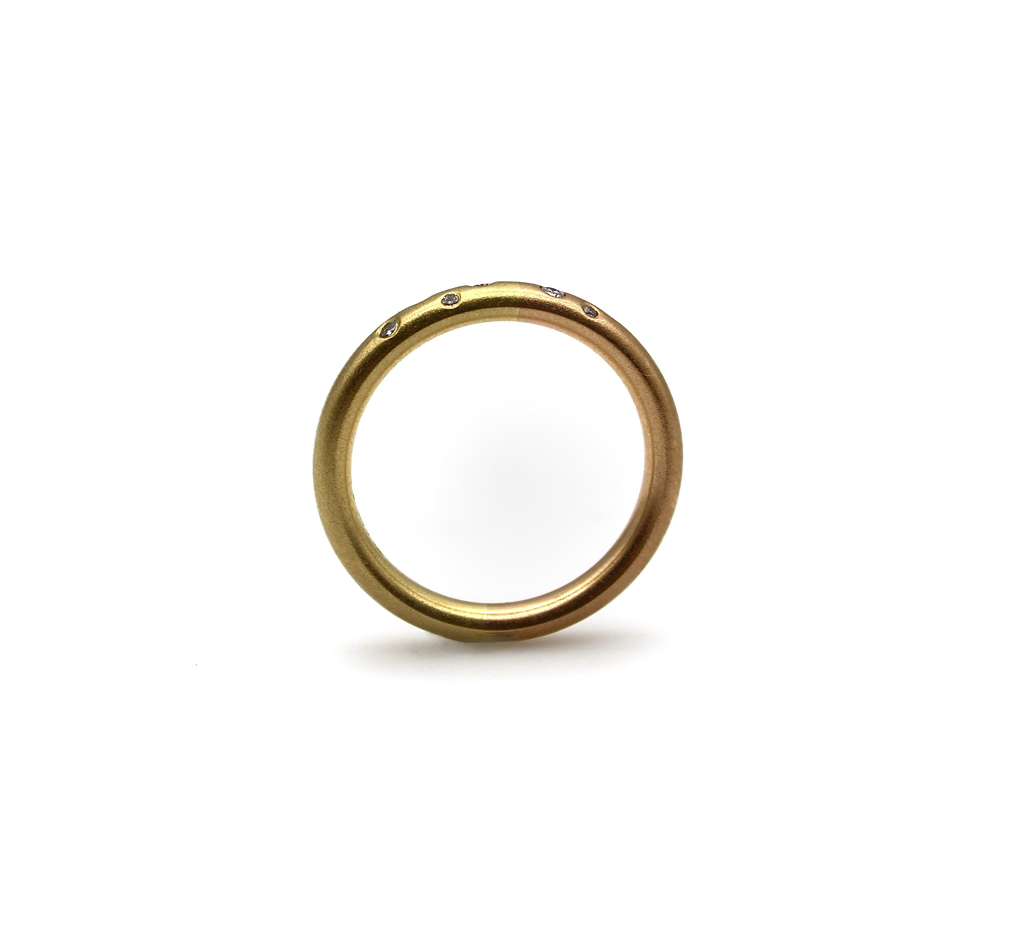 This adorable 18k gold band contains seven diamonds, placed like tiny stars in a classic Etoile design. The subtle variations in the gold aren’t obvious at first glance, but the ring is two-toned, creating a lovely effect. Half of the band is a