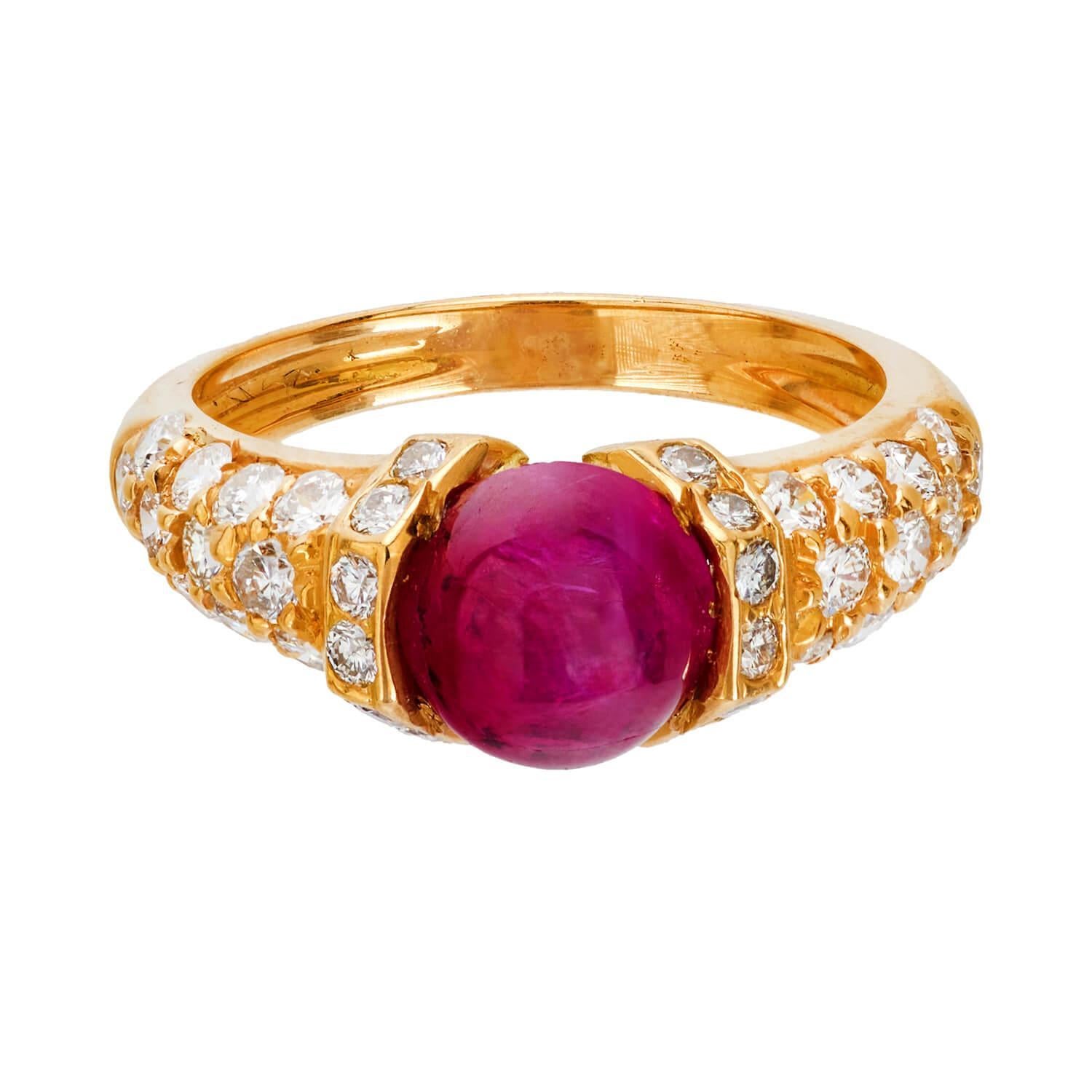 Un bellissimo anello con rubino e diamanti dell'epoca Vintage (ca. 1960)! Questo splendido pezzo è realizzato in oro giallo 18 carati e presenta un rubino birmano cabochon centrale da 1,20 carati. Il rubino è incastonato in una montatura a due punte