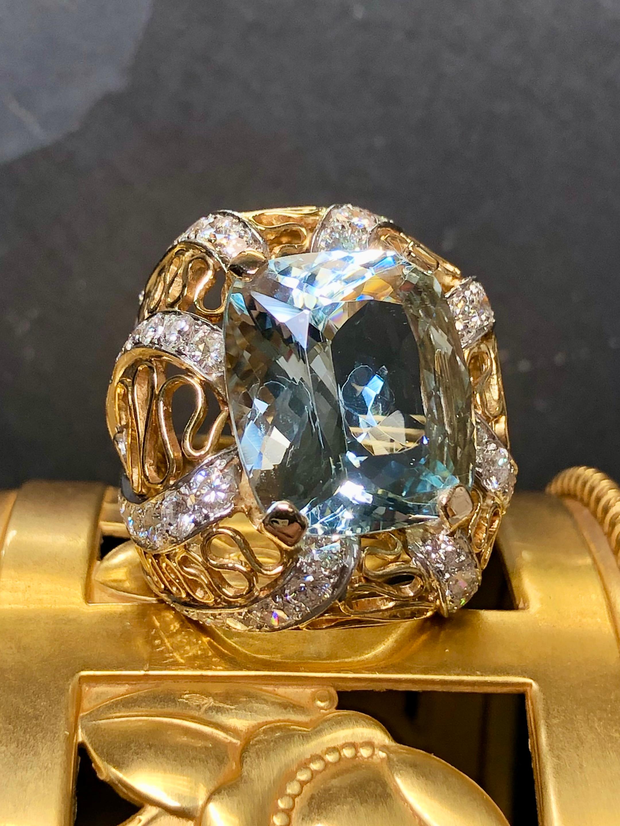 Now this ring is fabulously made. It is done in 18K yellow and white gold and centered by an approximately 20ct cushion cut aquamarine (17.82x15.58x10.18). Bead set down all sides of the ring are incredibly well matched collection quality diamonds