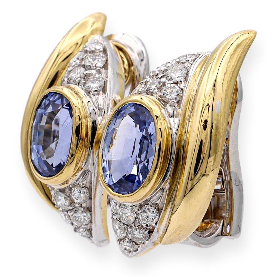 Pair of vintage earrings made in Italy finely crafted in 18 karat yellow and white gold featuring 2 oval cut blue sapphire centers identified by The Gemological Institute of America as Burma No-Heat,  set inside yellow gold bezels with a total carat