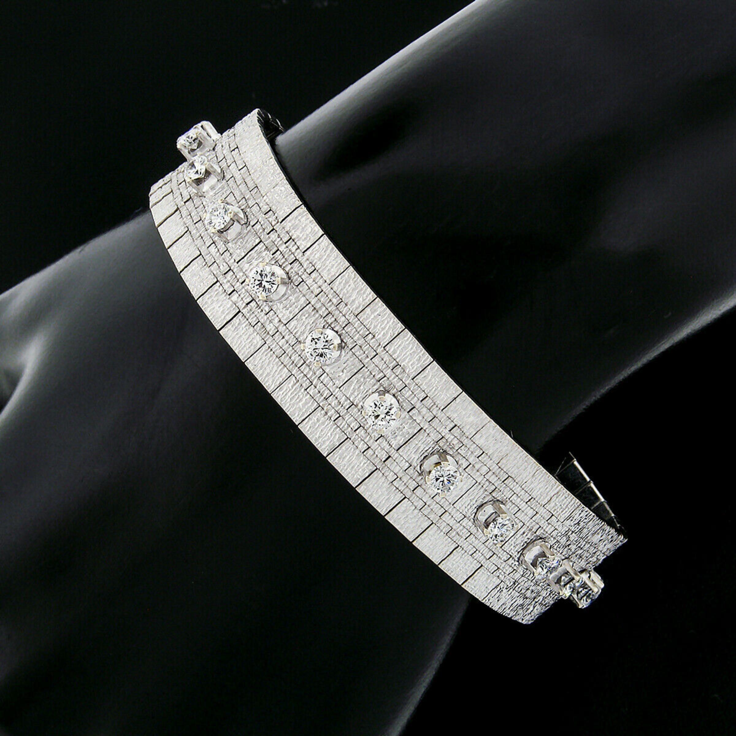 This outstanding vintage bracelet was crafted from solid 18k white gold and features a line of 22 prong set round brilliant cut diamonds. The bracelet is constructed from textured links assembled into an intricate brick pattern. The links flow