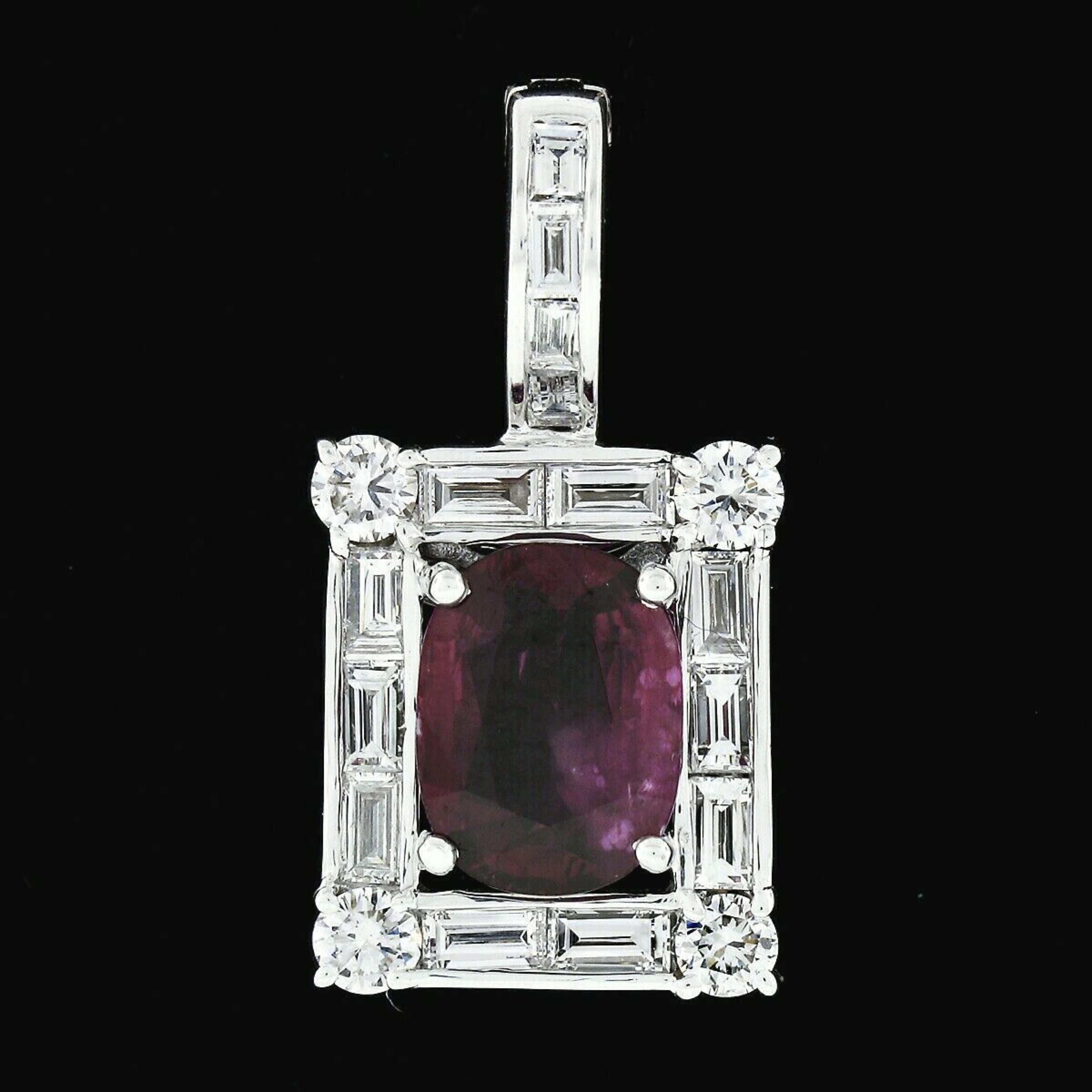 Here we have an absolutely gorgeous vintage ruby and diamond pendant that was crafted from solid 18k white gold. This pendant features an exactly 1.84 carat, GIA certified, oval cut ruby prong set at its center with a beautifully rich red color. The