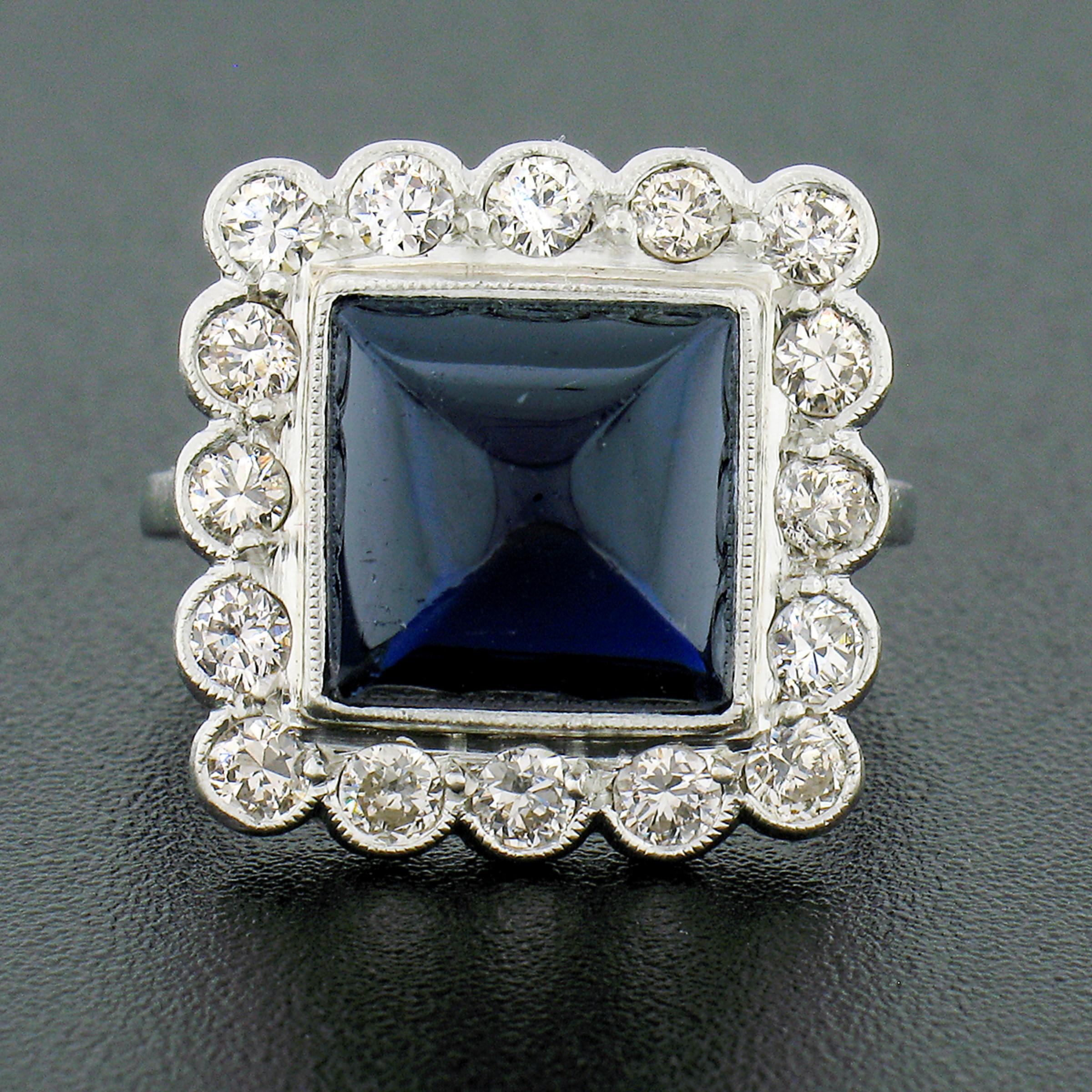 This gorgeous vintage sapphire and diamond ring was crafted in Sweden from solid 18k white gold. It features a large square sugarloaf cut natural sapphire milgrain bezel set at its center. This approximately 6.63 carat, GIA certified, Australian
