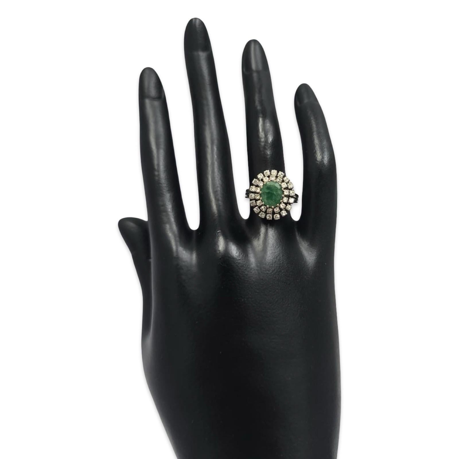 Ein exquisiter Vintage-Cocktailring aus 18 Karat Weißgold mit einem natürlichen Smaragd im Cabochon-Schliff von ca. 8,5 × 7,3 mm in der Mitte, umgeben von zwei konzentrischen Halos aus alten europäischen Diamanten und Diamanten im Einzelschliff. Der