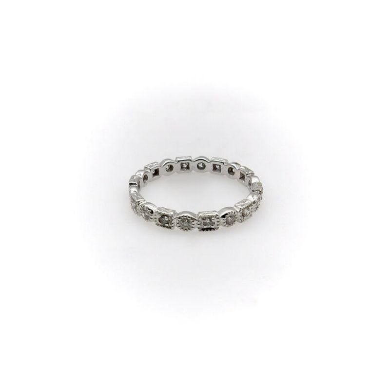 This sophisticated eternity band contains 20 1.5mm diamonds set in an alternating pattern of circles and squares. The millegrain work surrounding the diamonds adds a nice texture and compliments the sparkle of the diamonds.

Circa 1990, this ring is