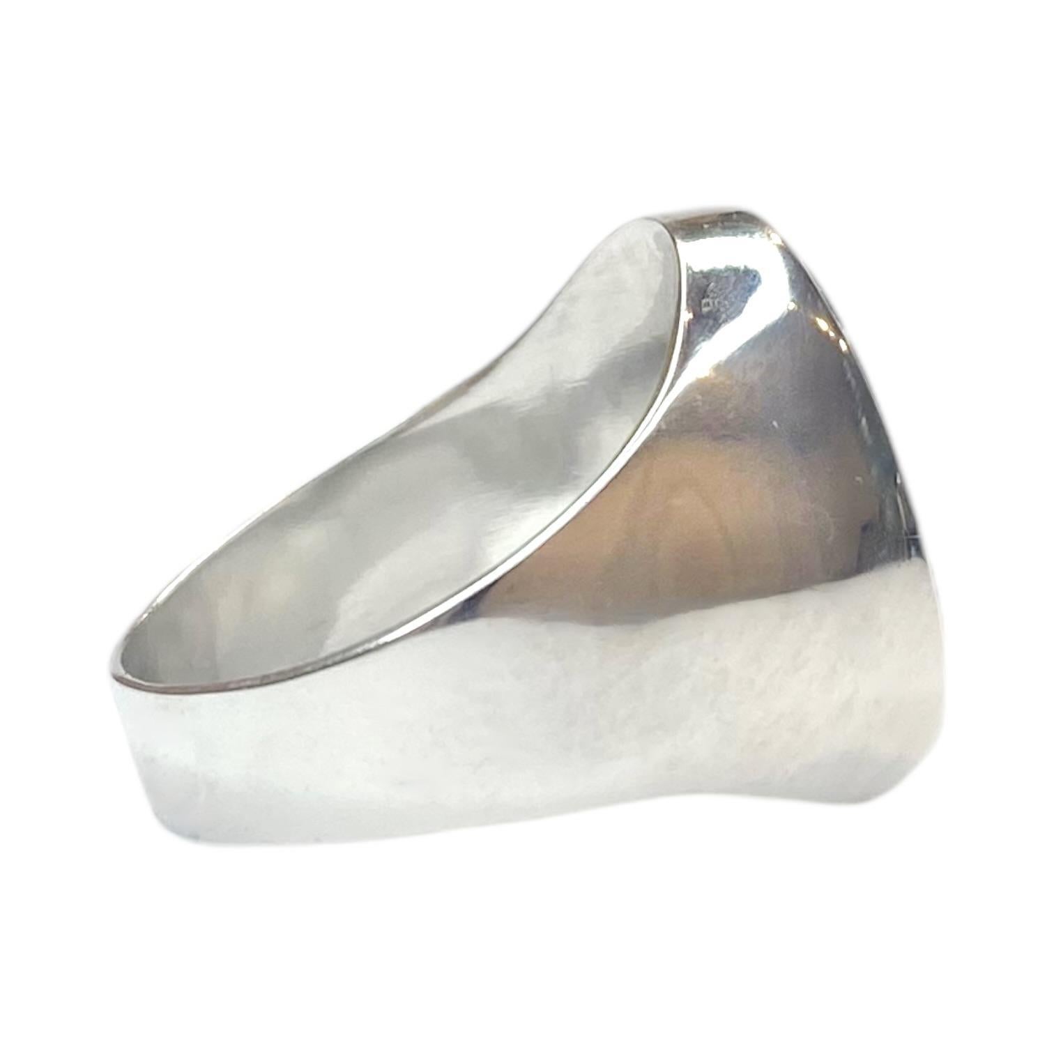 Vintage 18K white gold signet ring featuring an oval black onyx, adorned with a white diamond set 