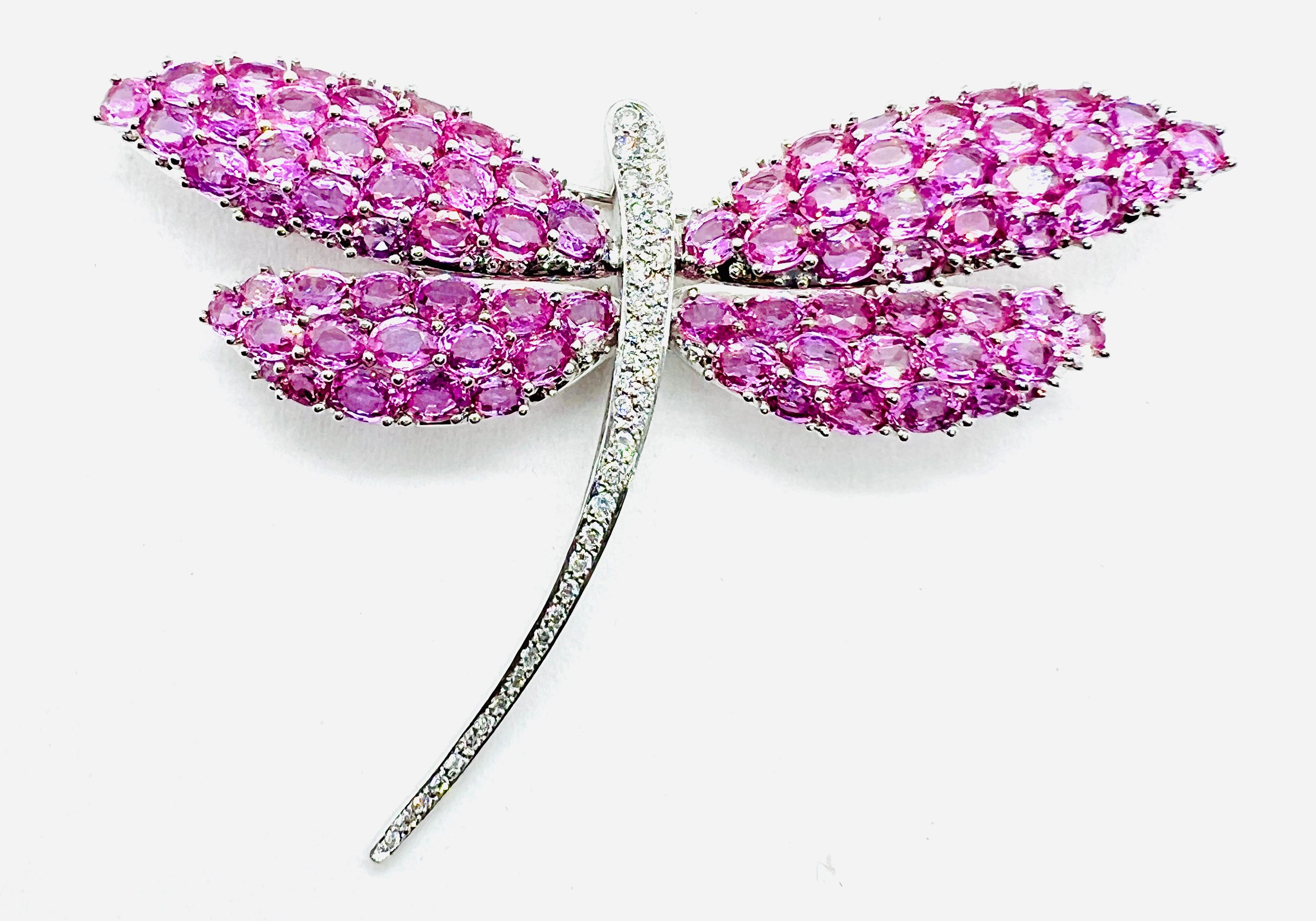Absolutely Stunning brooch! It is made in 18k White gold, measures 65 by 85 mm (3.5 inches by 2.5 inches) and weighs 31.84 grams. The wings of the dragonfly consist of 78 oval pink sapphires with a carat total weight of 23. The body of the dragonfly