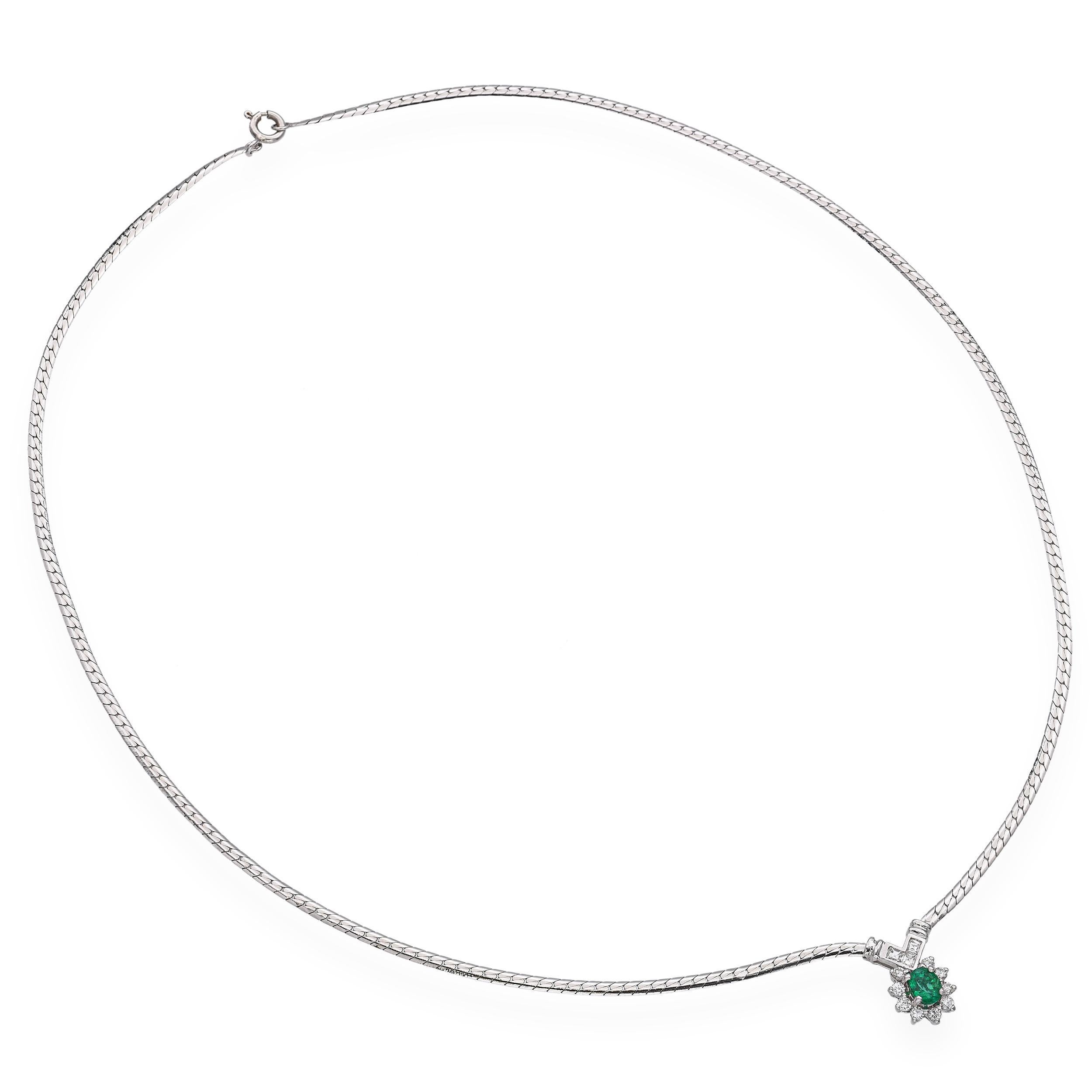 Questo elegante ciondolo vintage è realizzato in oro bianco 18 carati e presenta al centro uno smeraldo dalle tonalità intense. Intorno al vibrante smeraldo verde ci sono diamanti scintillanti che aggiungono brillantezza e contrasto al design.
