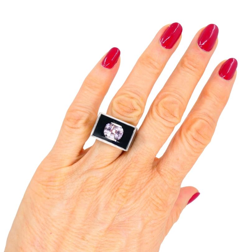 A gorgeous vintage 18k white gold, pink sapphire, and black enamel ring. The ring’s design centers around a rectangular top finished with black enamel. The pink sapphire is flush set into the enamel, giving the ring a refined edge. The gem’s soft