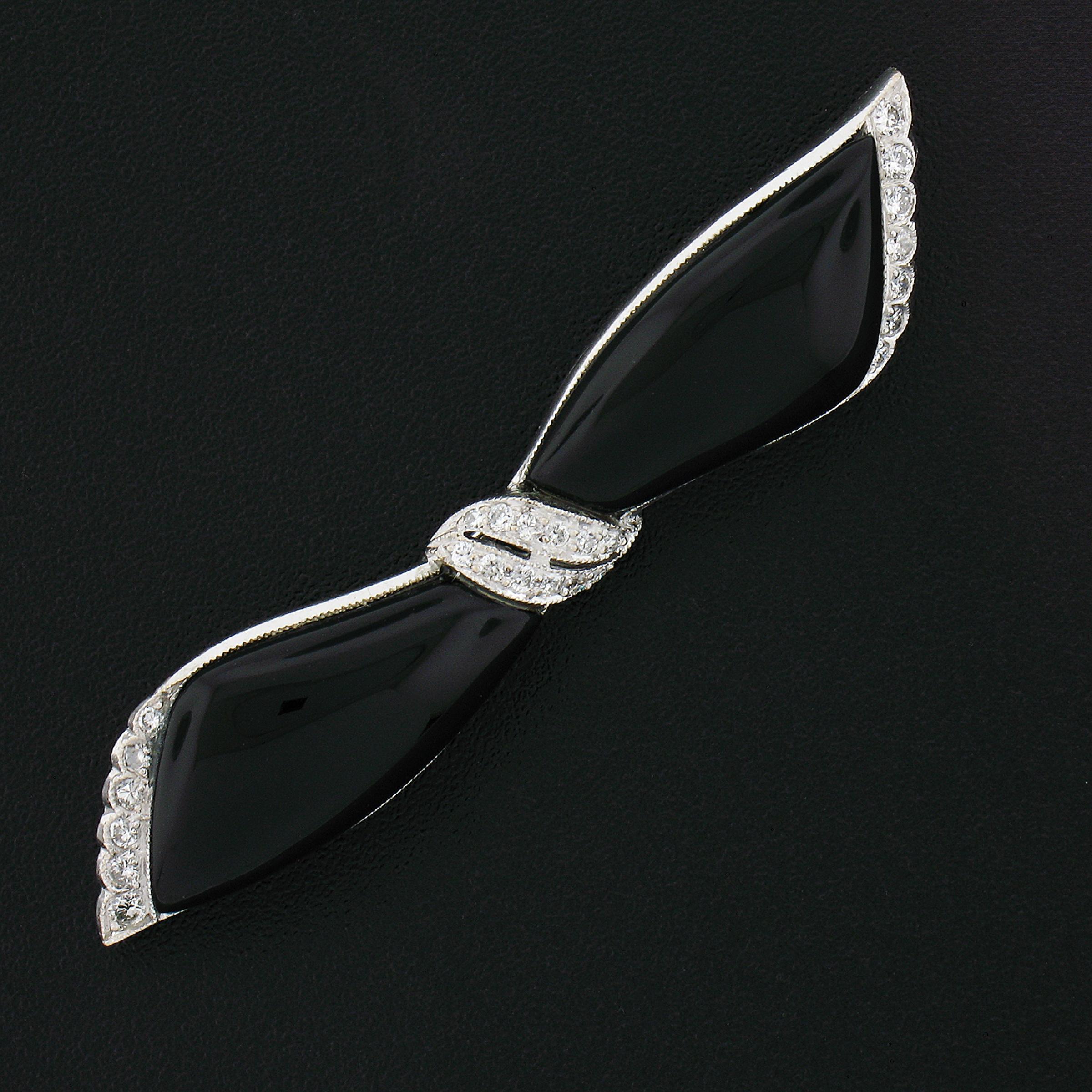 This super cute vintage pin/brooch was crafted in solid 18k white gold. It features an adorable bow design that is adorned with custom cut polished black onyx and accented with round brilliant cut diamonds that are pave set on the edges and center