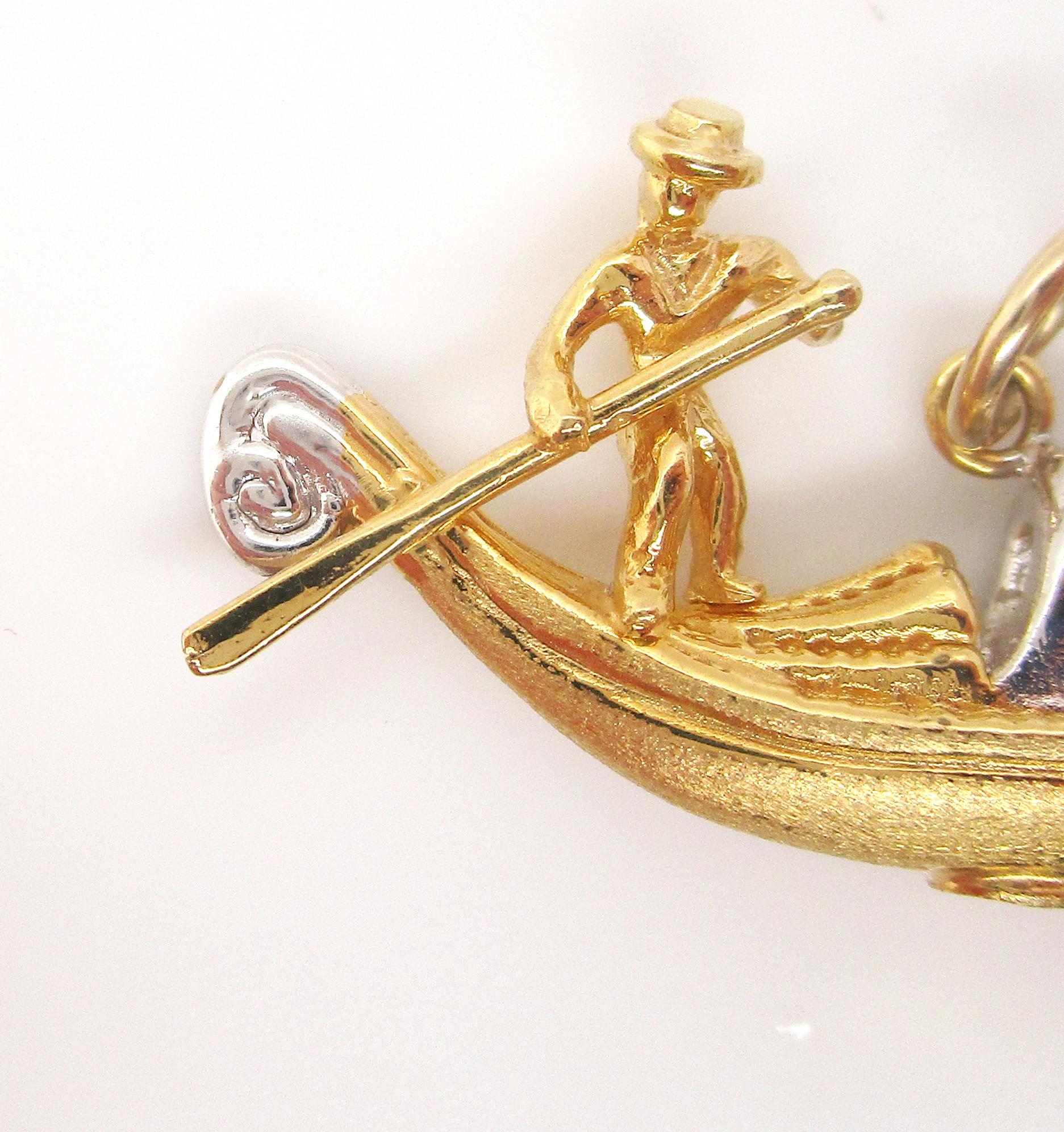 This beautiful vintage charm pendant is in 18k gold, both yellow and white, and is a three-dimensional representation of an Italian gondolier guiding his golden gondola down the invisible waters of Venice. The charm has a subtle textured finish that