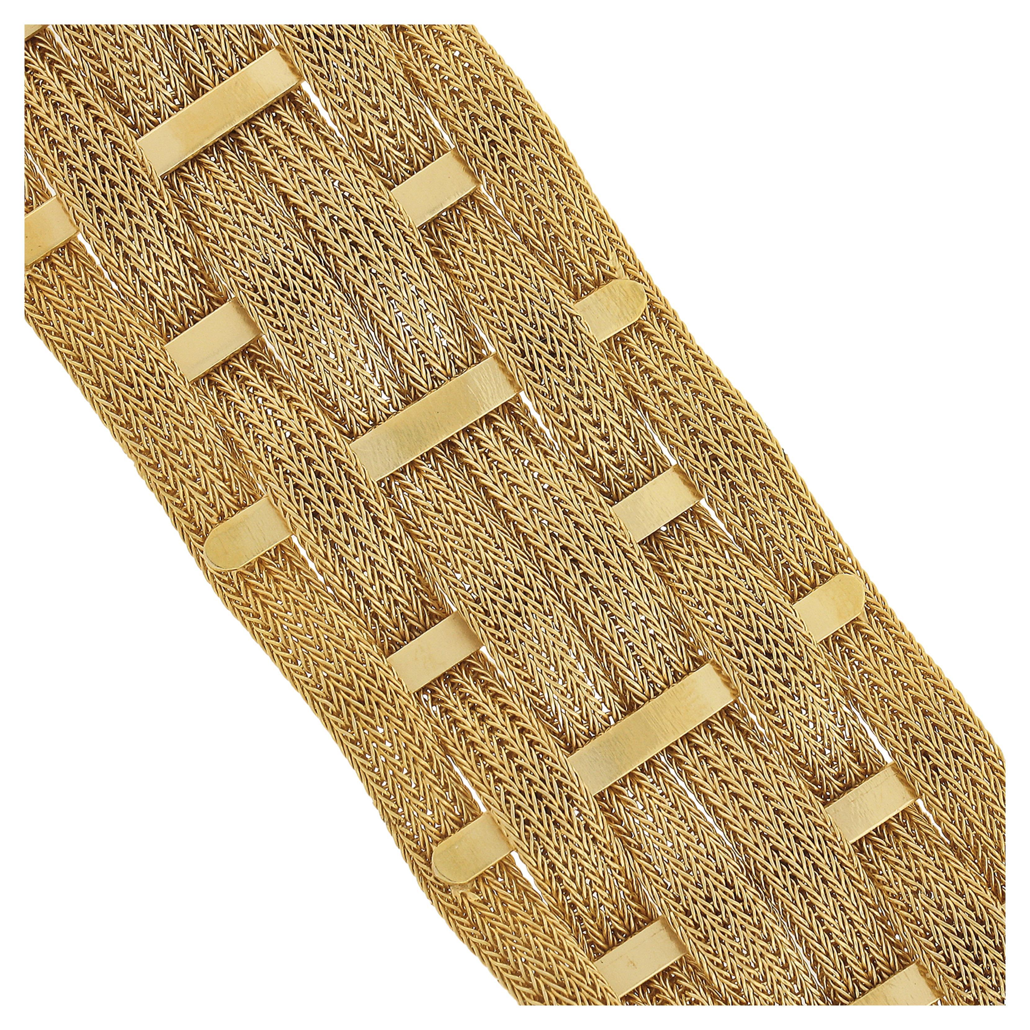 This truly elegant and unique vintage bracelet was crafted in solid 18k yellow gold and features approximately 1.1 inch wide woven mesh link that is silky smooth on the wrist. The bracelet consist of 6 woven chains that uniquely wave up and down and