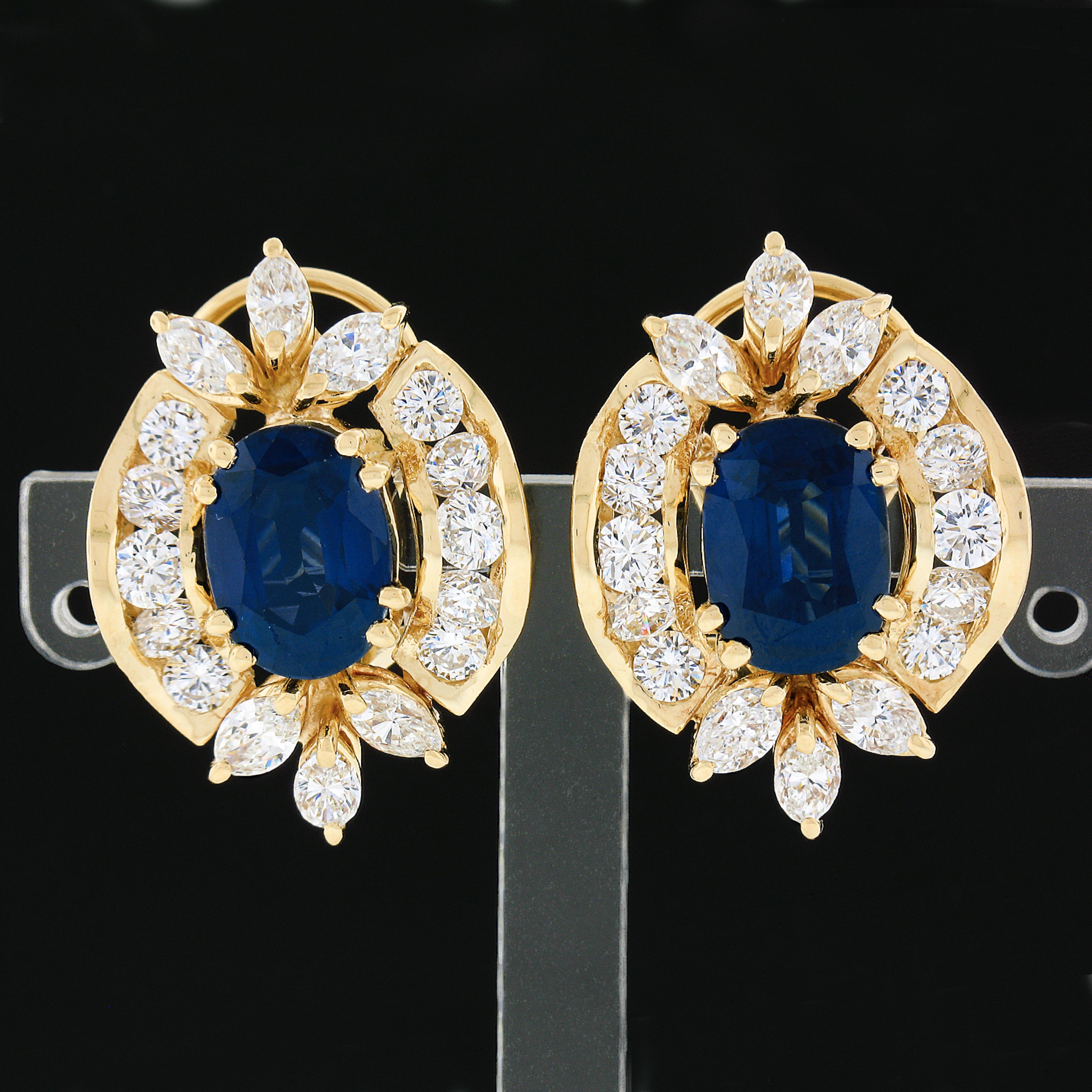 This breathtaking pair of vintage statement earrings is crafted in solid 18k yellow gold and feature very fine oval sapphire stones neatly set at the center surrounded by absolutely stunning diamonds throughout. The large, GIA certified, sapphires
