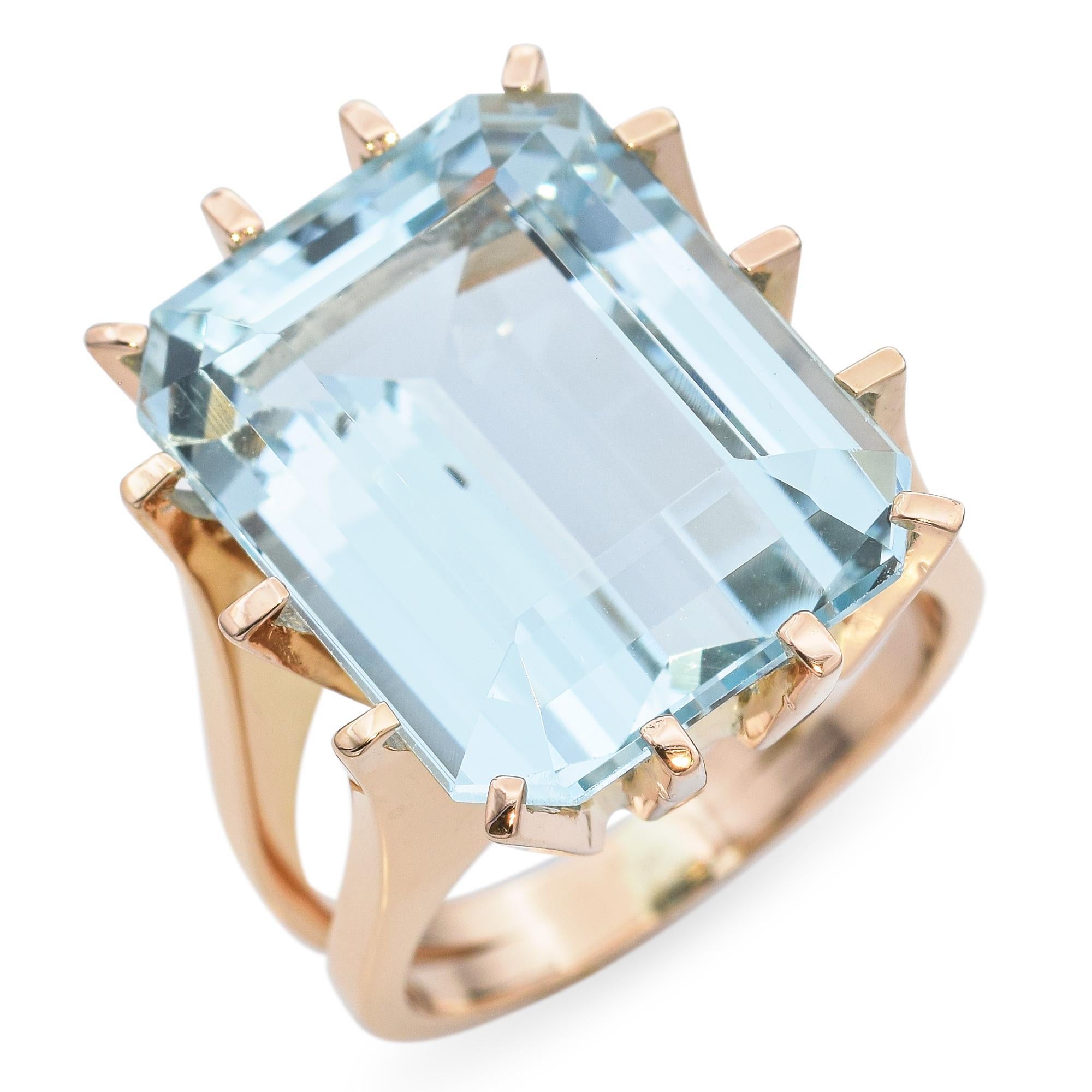 Cette bague vintage remarquable met en valeur une aigue-marine époustouflante de 16,6 carats sertie dans un luxueux or jaune 18 carats. La grande pierre précieuse à facettes présente une teinte bleue vive et glacée qui capte magnifiquement la