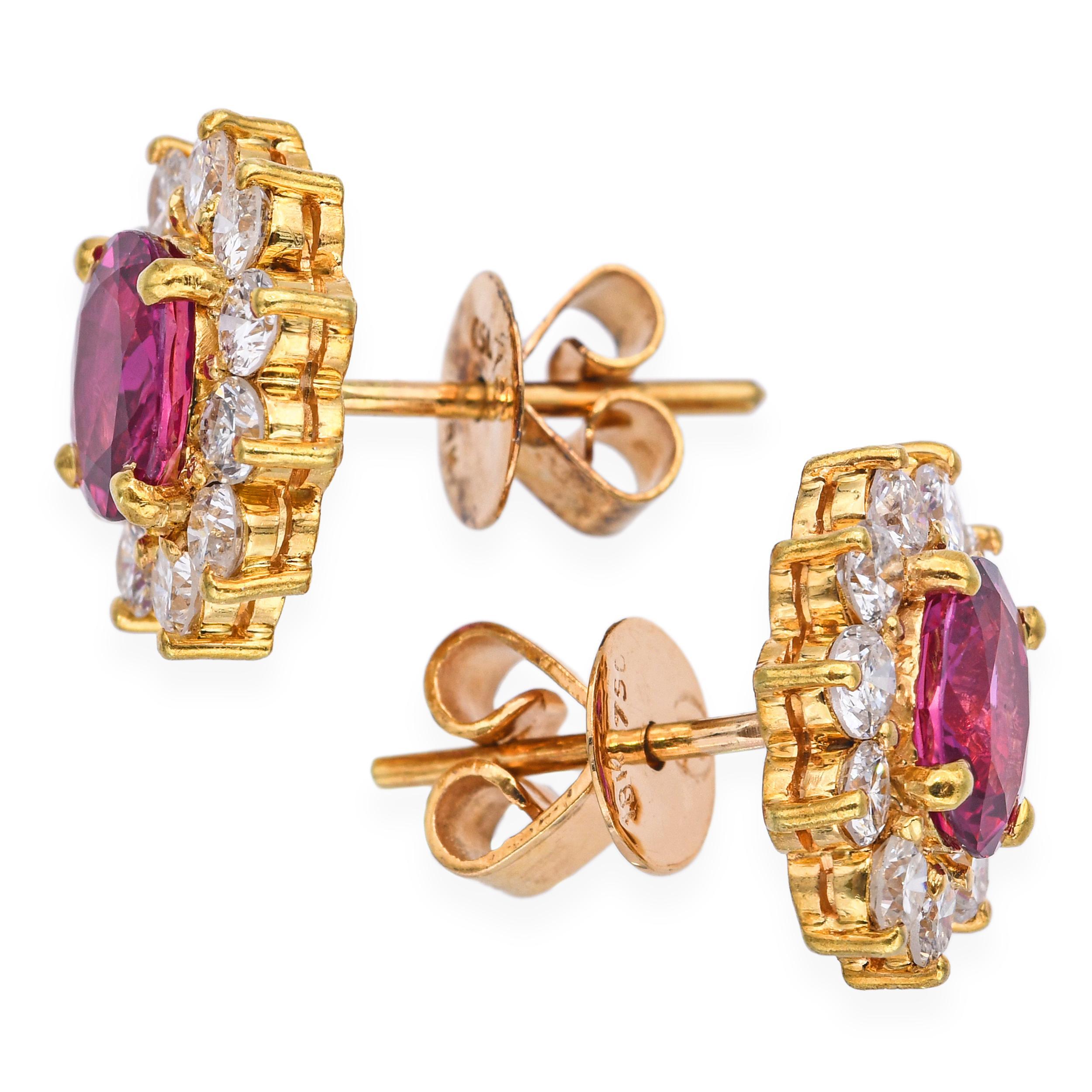 These luxurious vintage stud earrings are crafted in 18k yellow gold and feature 2.01 total carats of vibrant rubies as the focal point. Surrounding each ruby is a halo of sparkling diamonds totaling 0.66 carats, adding brilliance and enhancing the