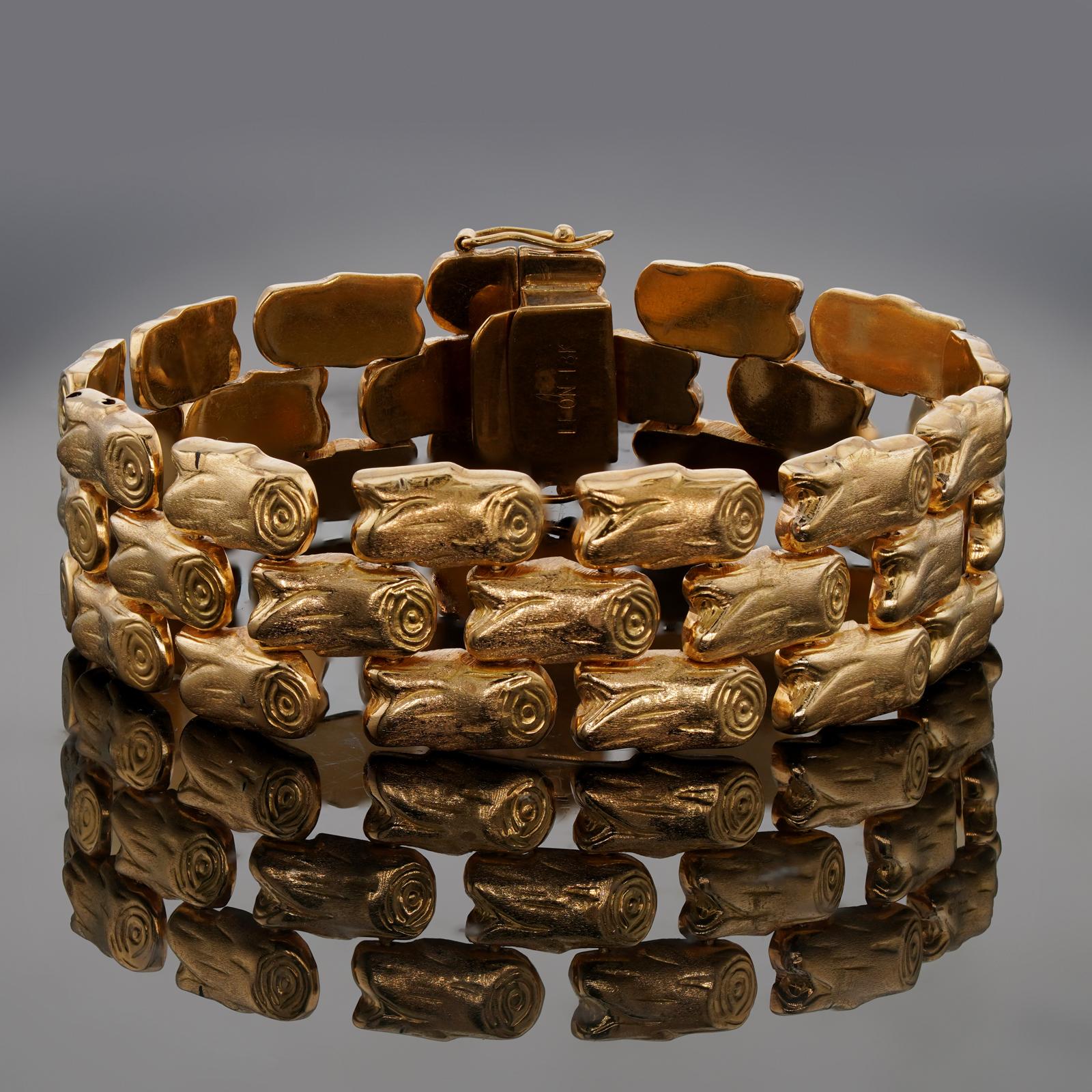Ce bracelet vintage chic est composé de trois rangs de maillons en or jaune texturé 18 carats. Fabriqué aux États-Unis vers les années 1980. Dimensions : 0,78