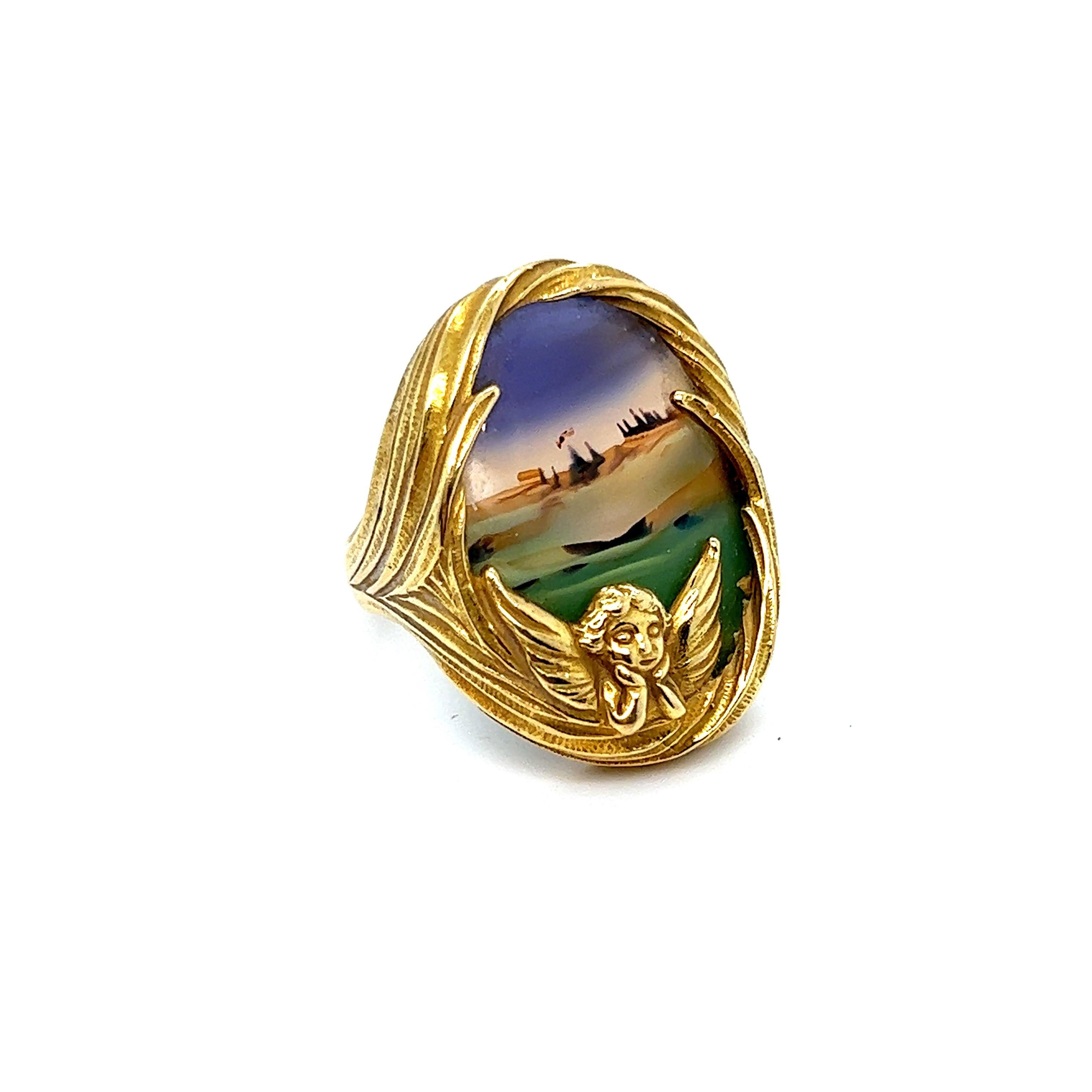 Hi there Gorgeous! I knew when I saw this special, one of kind, piece I had to have her. Crafted in 18K Yellow Gold, the ring features a stunning and beautiful landscape agate, set into a whimsical flowing ring with a cherub looking on. Very well