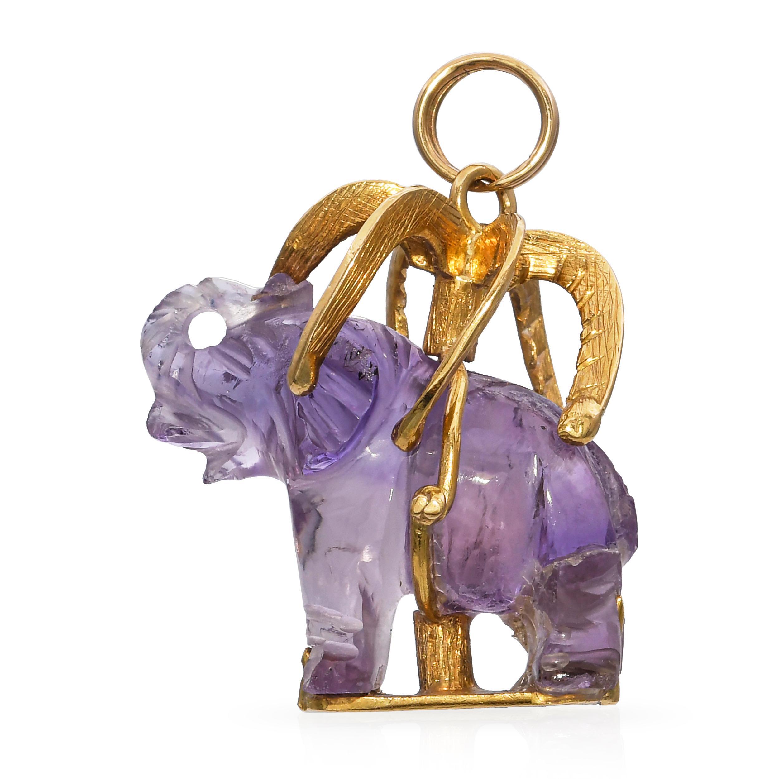 Un ciondolo vintage stravagante e finemente realizzato in oro giallo 18 carati, con un elefante che riposa sotto una palma. Il disegno raffigura una scena serena, con l'elefante reso con una dettagliata lavorazione in oro, che simboleggia saggezza,