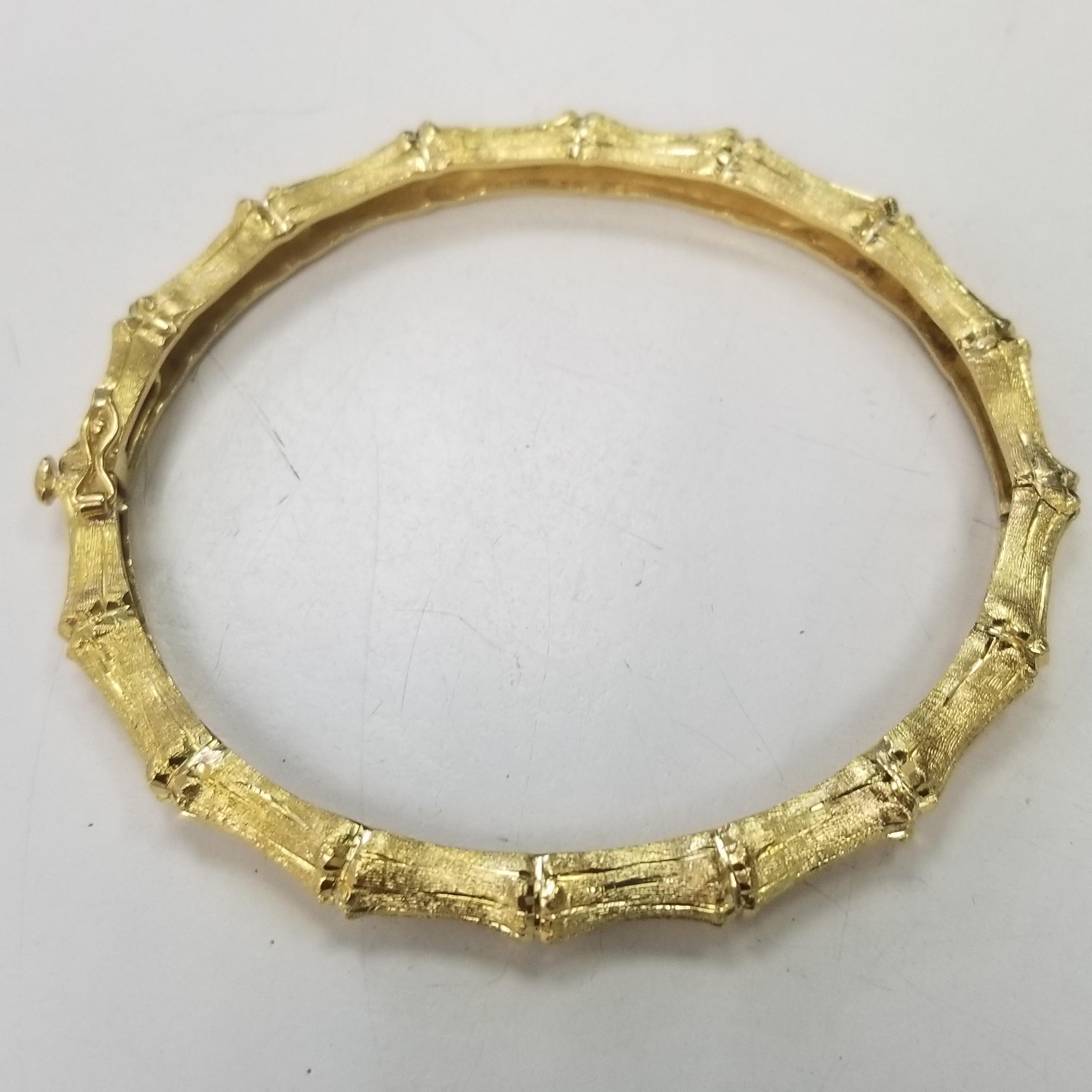 So stylish yet a classic in its own right. This bamboo-style bracelet features the unique design with a hand engraved finish in 18kt yellow gold. A bold look and a comfortable feel, you'll wear this stacked or alone every day! Hinged, 18kt yellow