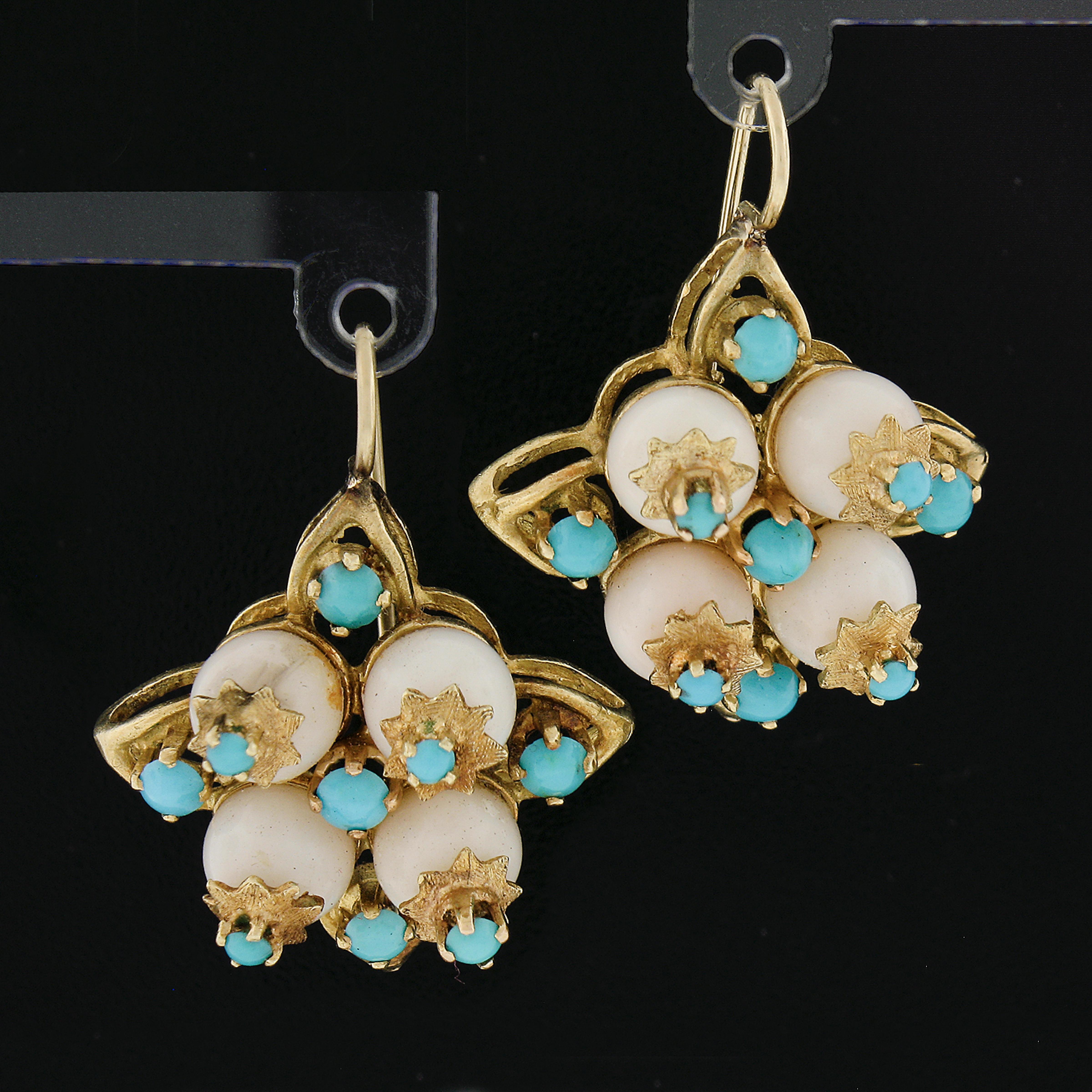 Here we have a beautiful pair of vintage drop dangle earrings that are crafted in solid 18k yellow gold. They each feature a 8 bead shape angel skin coral neatly sets in a floral basket design. The corals are adorned with 16 turquoises adding a