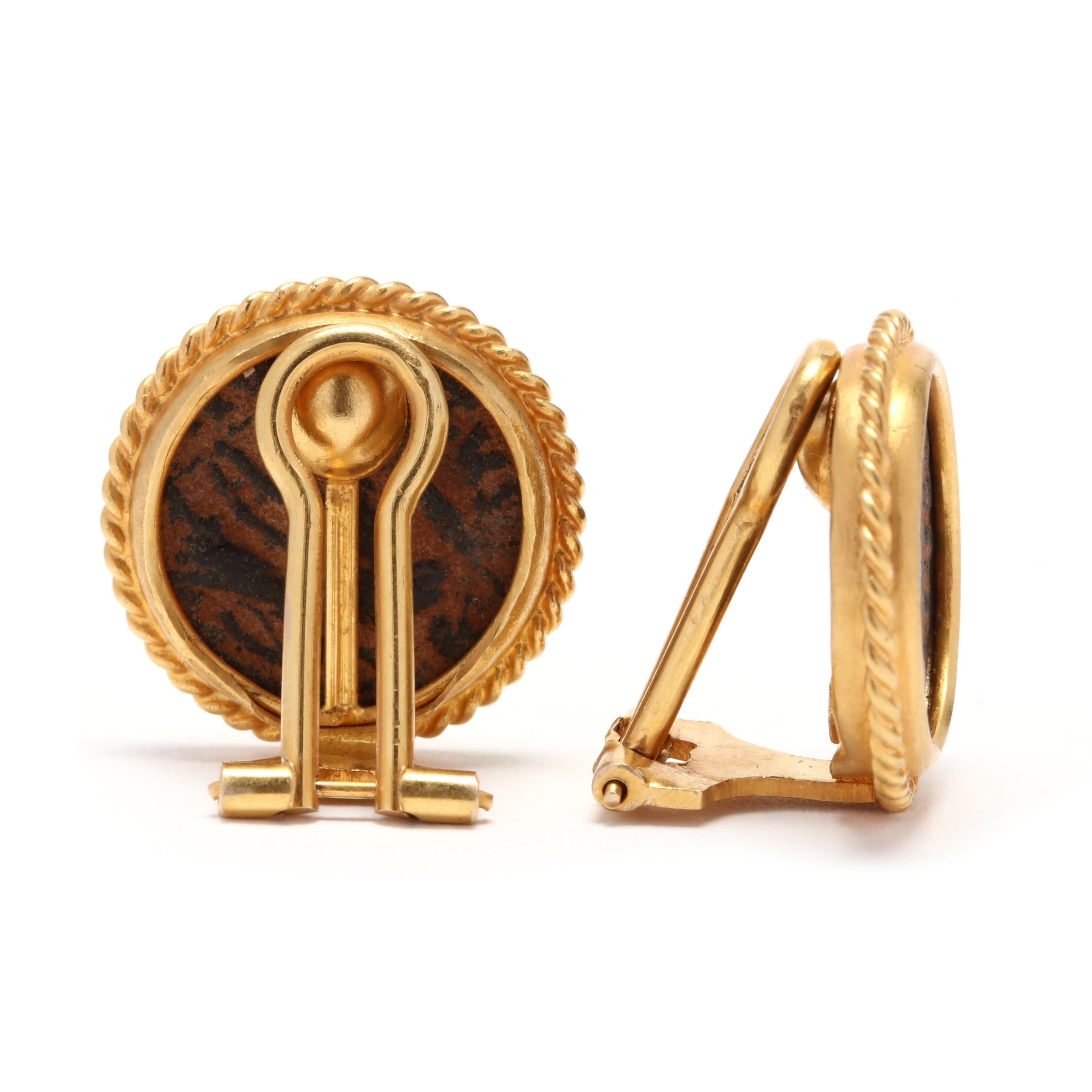 A pair of vintage 18 karat yellow gold and bronze Roman coin clip on earrings. These earrings feature bezel set, round Roman coins surrounded by a rope motif border with omega clip backs.

Length: 3/4 in.

8.17 dwts.

* Please note that this is a