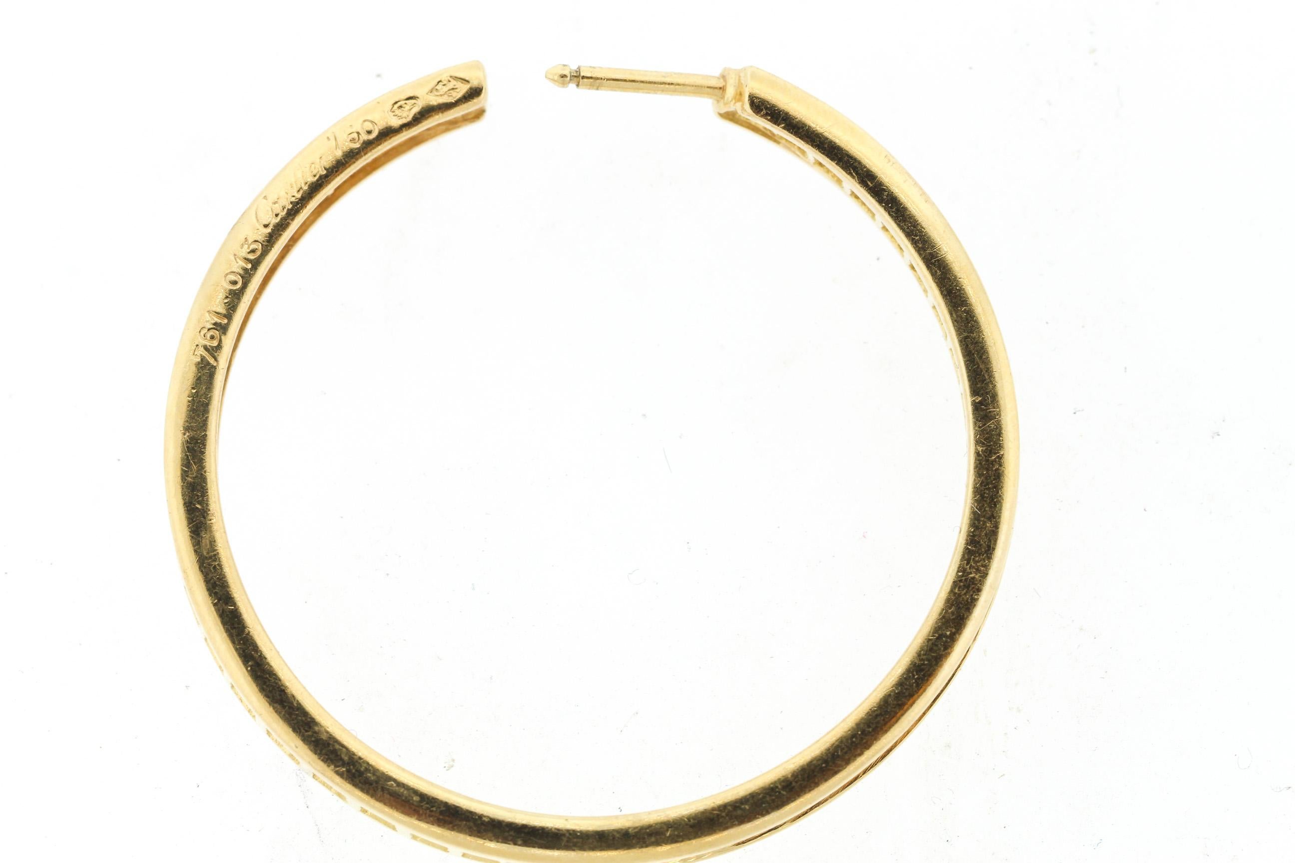 Classic 18k yellow gold diamond hoop earrings by Cartier circa 2000. The larger size hoop earrings are made with an inside out design where the diamonds are visible from all angles. The earrings make a statement and yet timeless in design. The