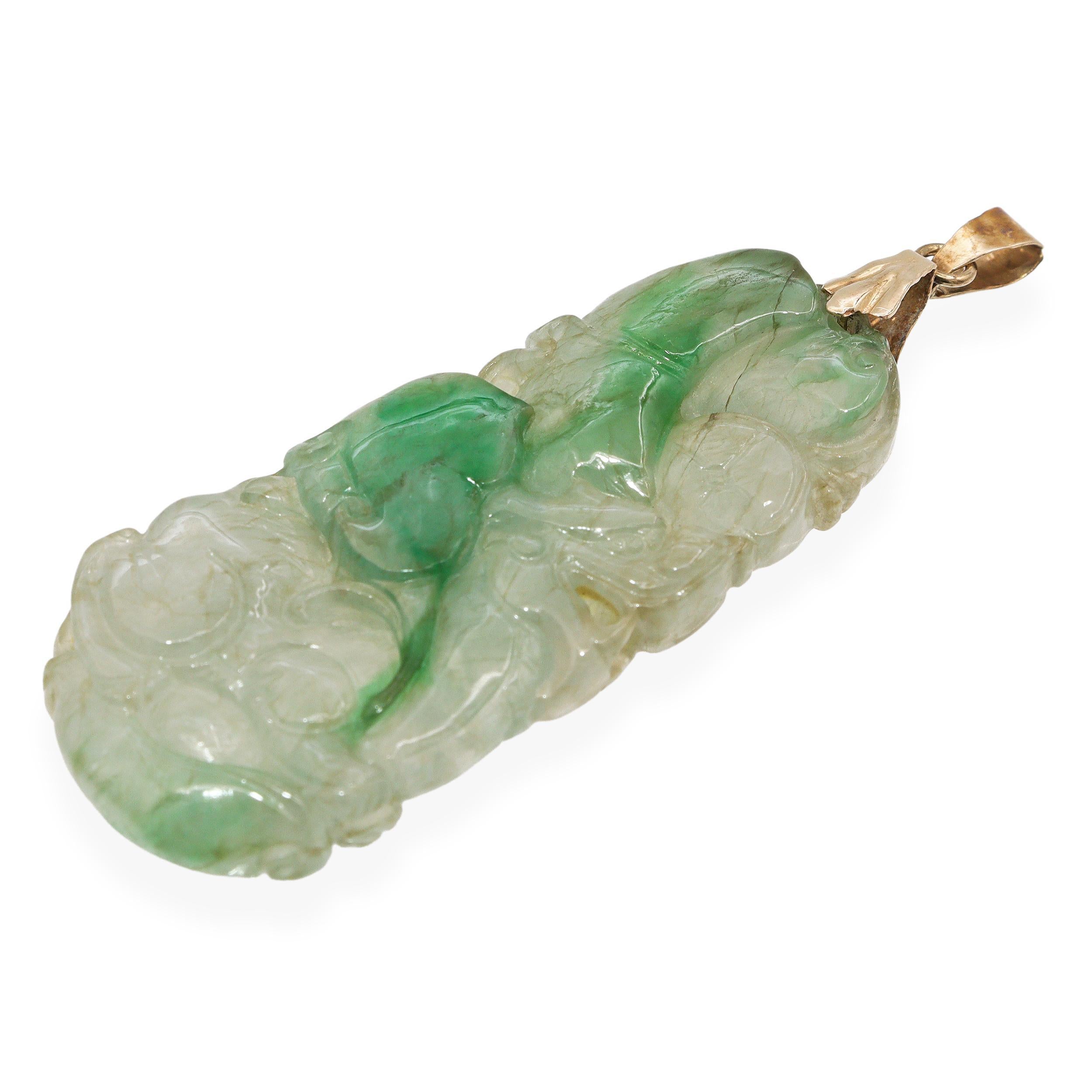 Questo ciondolo presenta una splendida pietra di giada intagliata a mano, che mostra una miscela naturale di tonalità verde traslucido e celadon chiaro. La giada è intricata con motivi vorticosi che mettono in risalto l'arte tradizionale e la