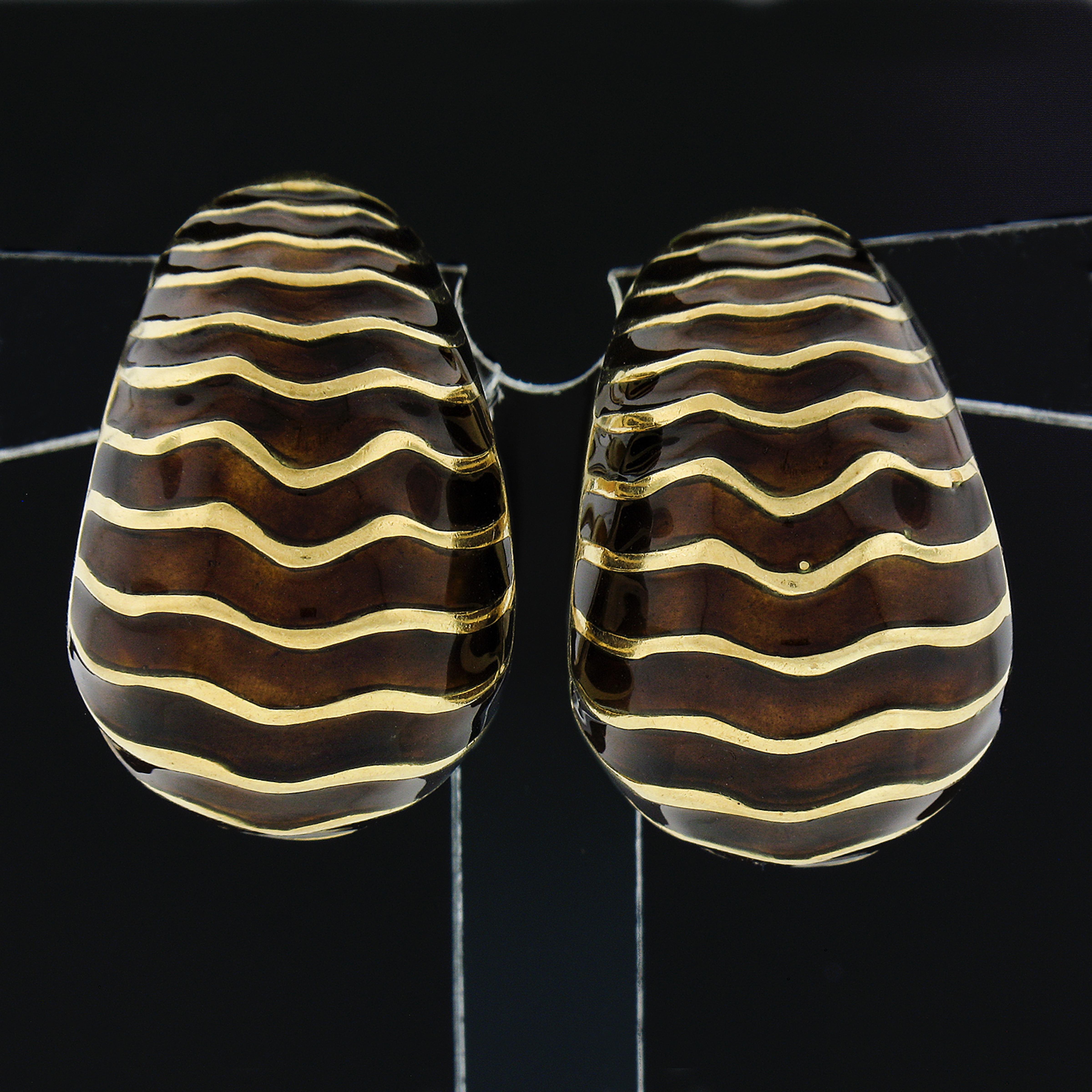 These large and absolutely beautiful vintage cuff earrings were crafted in from solid 18k yellow gold. They feature a bold yet super elegant design that widens at its bottom, displaying a lovely alternating wavy pattern of high polished yellow gold