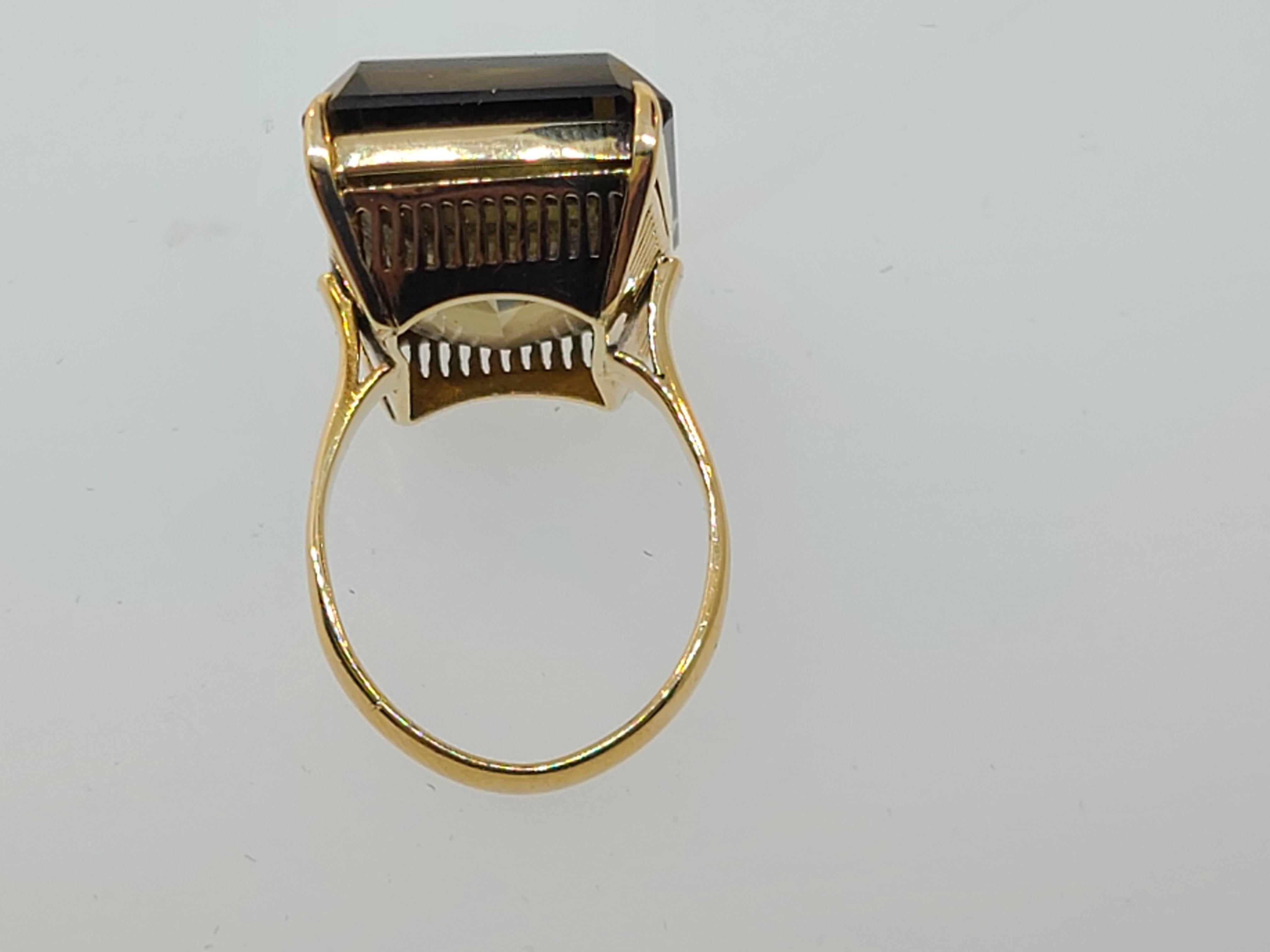 This vintage 1970's custom made 18k yellow gold ring is finely crafted in a bright polished finish featuring attention to craftsmanship and design with an ode to vintage elegance.  The large 20mmx15mm emerald cut natural citrine solitaire stones is