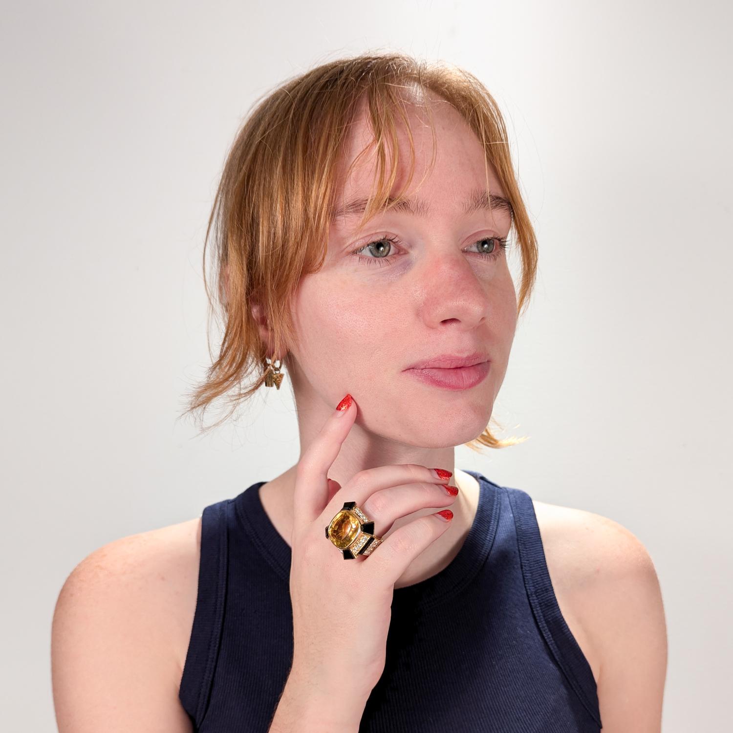 A fine vintage gold, citrine, onyx, and diamond cocktail ring.

In 18 karat yellow gold.

With a large cushion mixed cut 18.40± ct citrine (transparency: transparent, color hue: yellow, saturation: moderate) to the center. 

The square face flanked