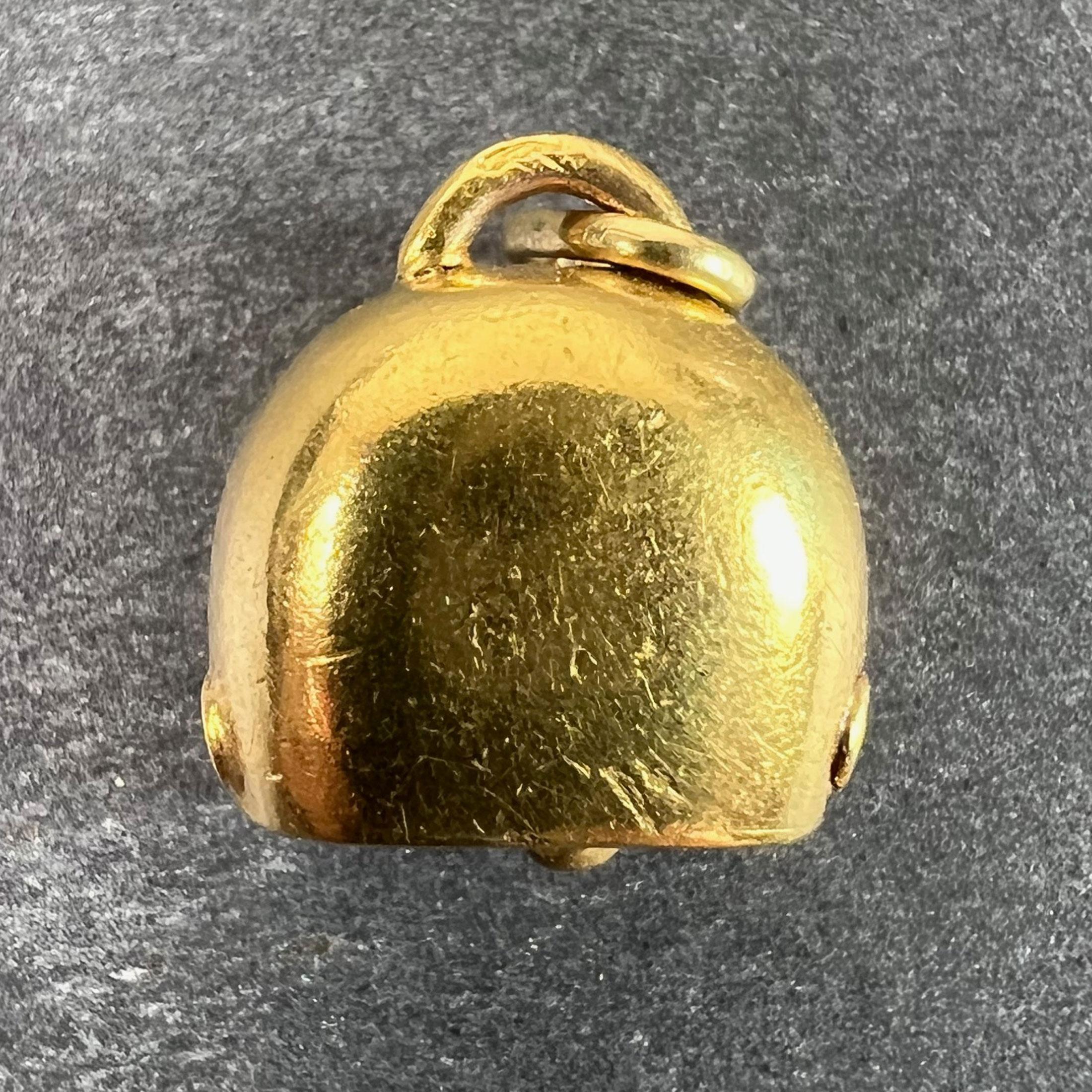 A vintage 18 karat (18K) yellow gold charm pendant designed as a lucky cow bell. Stamped with the owl mark for 18 karat gold and French import.

Dimensions: 1.3 x 1.2 x 0.7 cm (not including jump ring)
Weight: 1.49 grams
(Chain not included)