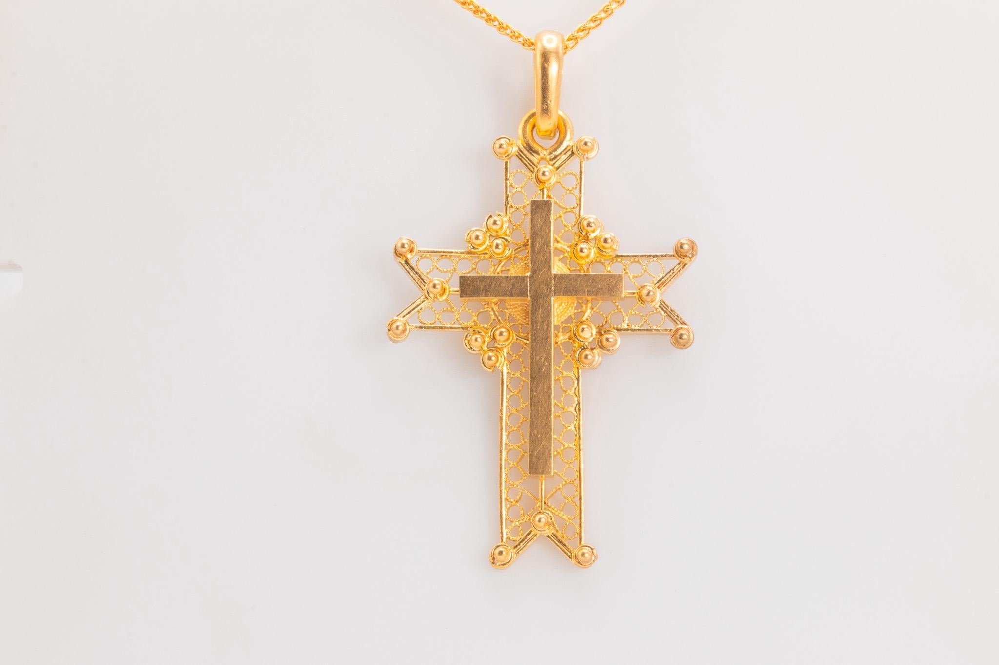 Ce pendentif en forme de croix datant des années 1980 est réalisé en or jaune 18 carats. Il mesure 2 pouces de haut et présente un design audacieux mais élégant. Associée à une nouvelle chaîne en or jaune 18 carats, longue de 20 pouces et large de 1