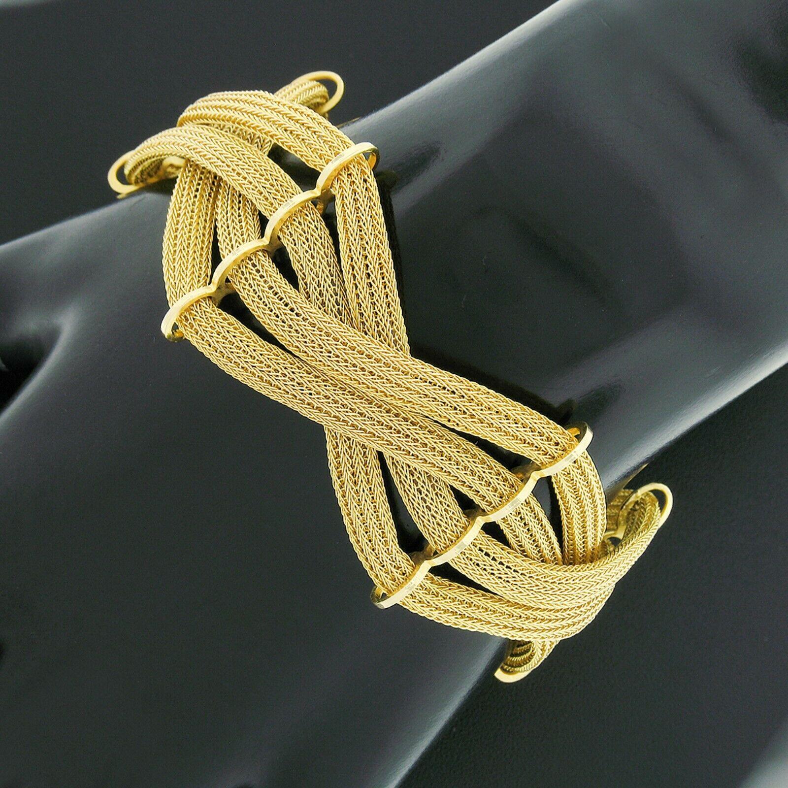 This well made and unique vintage bracelet was crafted in the 1960's from solid 18k yellow gold. It features a wide, woven, crossover design constructed from four strands of fine flat gold mesh with connecting links that keep them neatly in place.