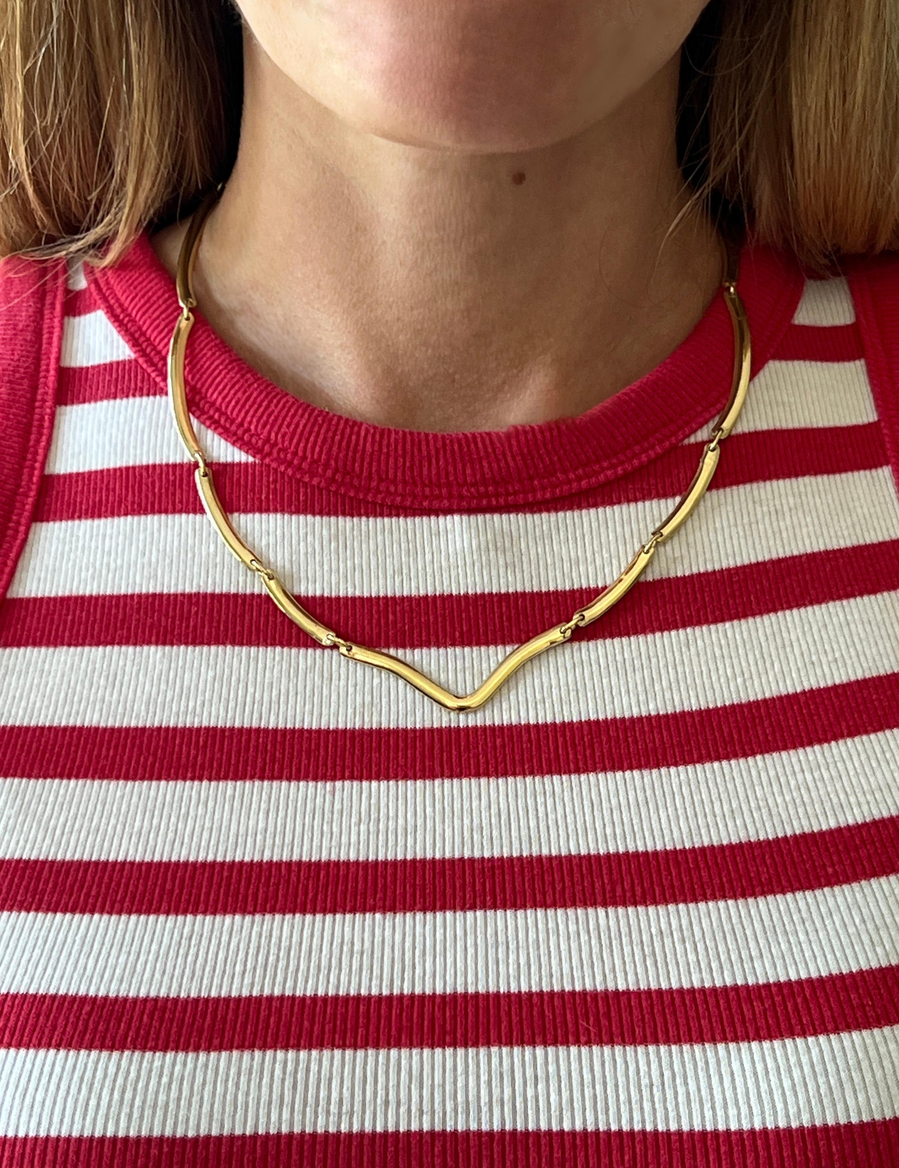 Este elegante collar de los años 80 está elaborado en oro amarillo de 18 quilates y presenta un elegante diseño de eslabones curvados que se extiende con gracia a lo largo del escote. Mide entre 17 y 18 pulgadas de largo y 3,7 mm de ancho, y se