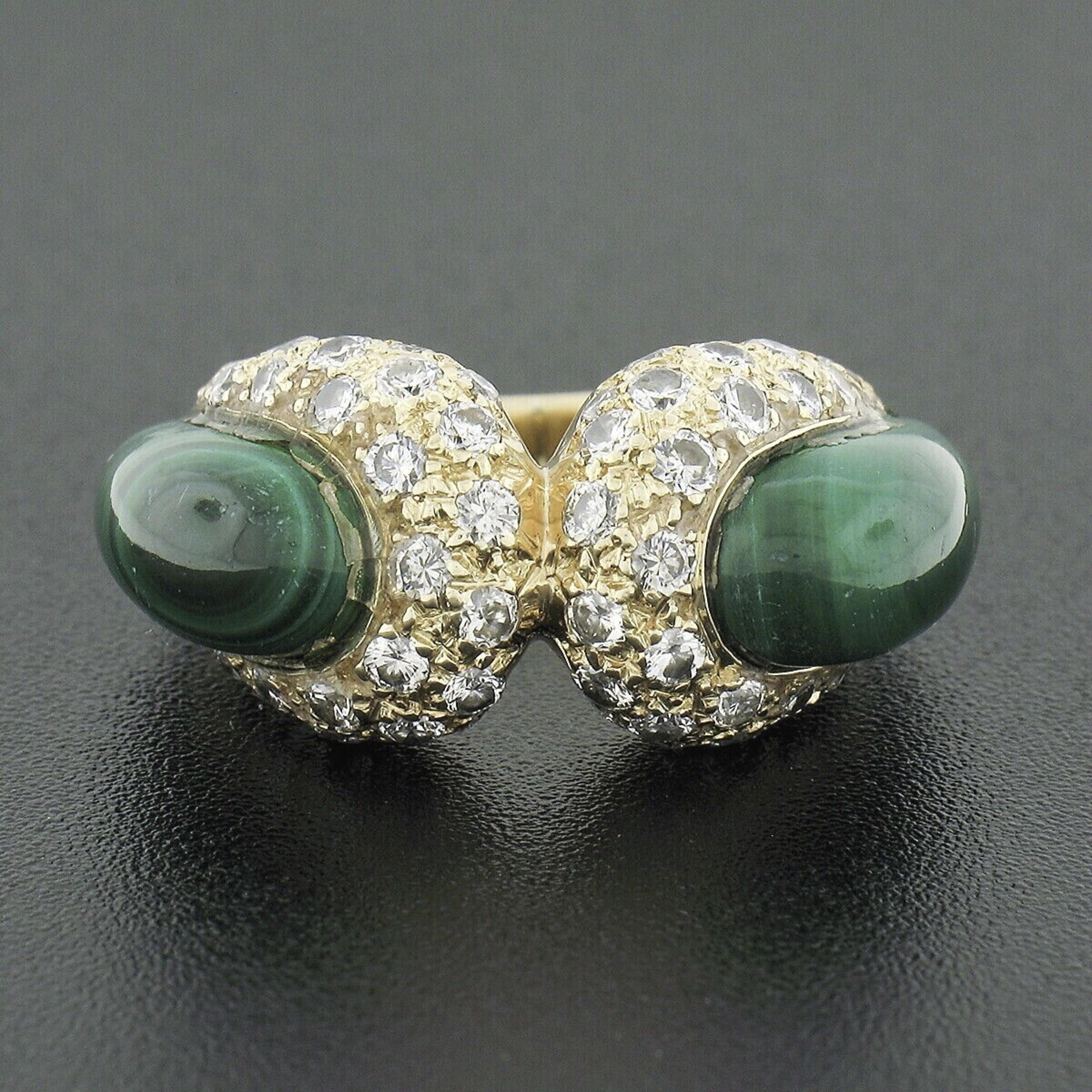 This stunning vintage ring was crafted in solid 18k yellow gold and features a unique design that is elegantly set with fine malachites and diamonds throughout. The custom cabochon cut malachites are set at the sides, showing an absolutely gorgeous