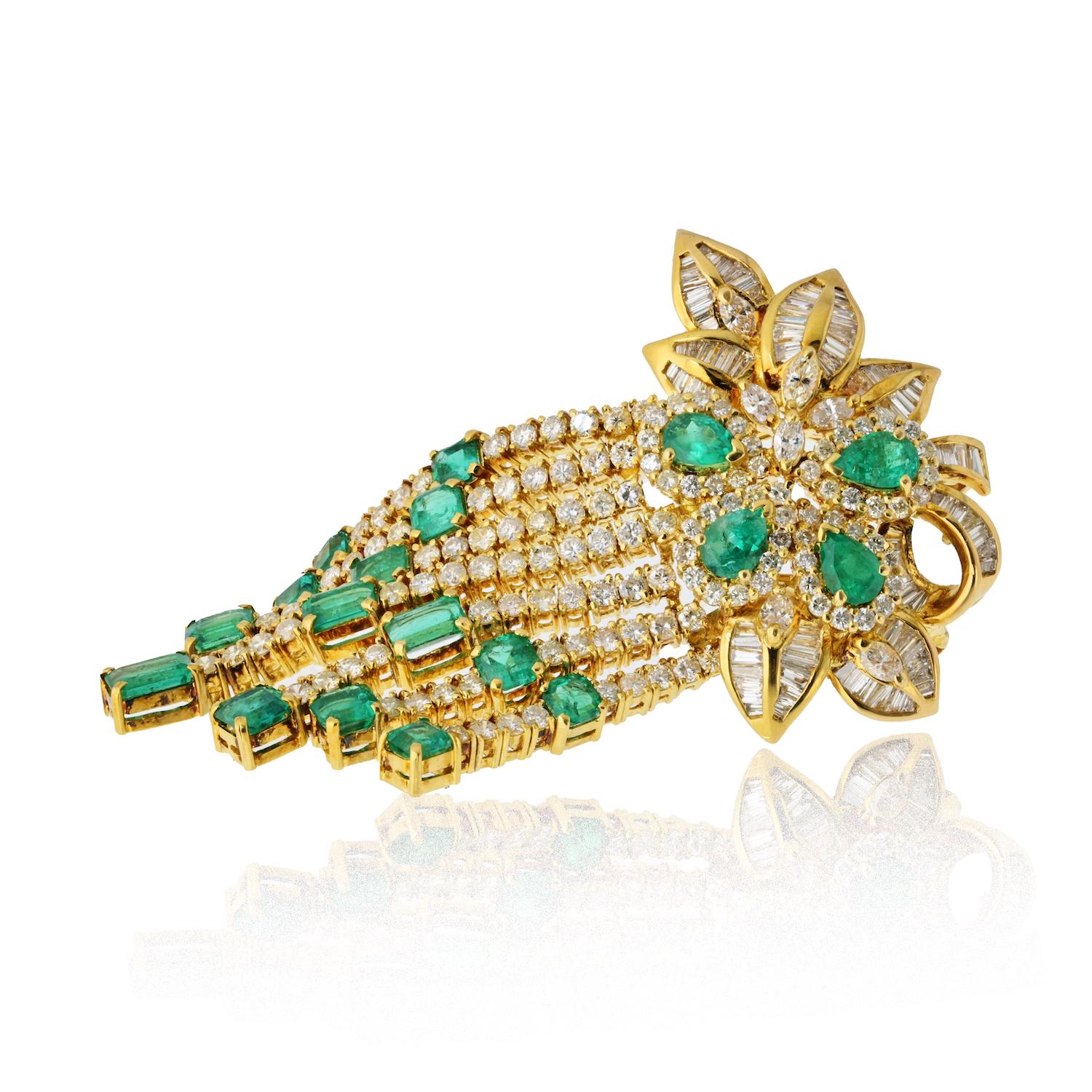 A bold and elegant piece from the 1970s, this vintage brooch is crafted in rich 18K yellow gold and showcases a striking combination of emeralds and diamonds. Designed with graceful movement in mind, the brooch features softly swinging ends that