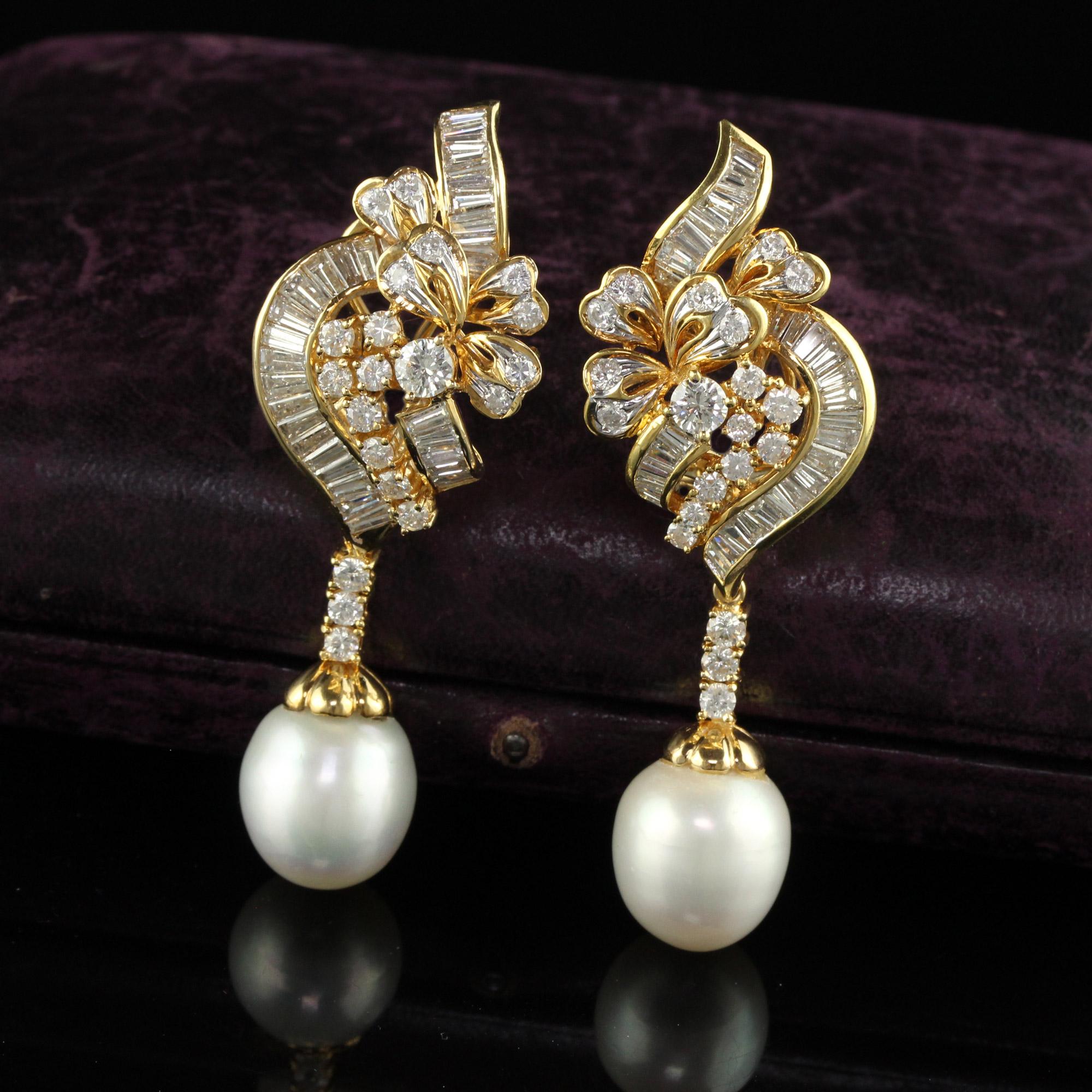 Beautiful Vintage 18K Yellow Gold Diamond and South Sea Pearl Drop Earrings. This gorgeous pair of diamond and pearl drop earrings are crafted in 18k yellow gold. There are baguette and round cut diamonds set in a floral design that have a fabulous