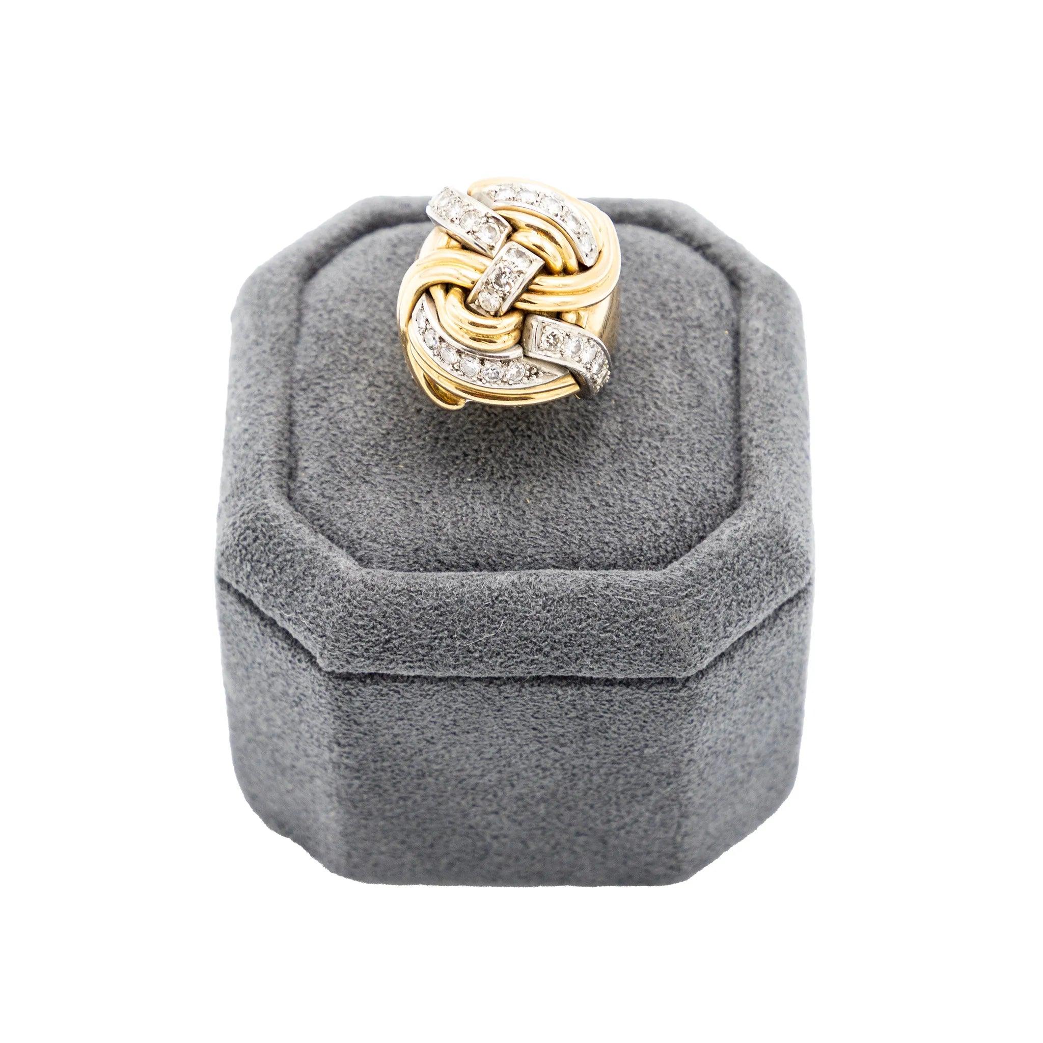 Un sorprendente anello scultoreo degli anni '40, realizzato in oro giallo 18 carati con dettagli in platino e diamanti a taglio brillante. Disegnato con un audace motivo a nodi, questo pezzo intreccia curve d'oro lucido con nastri di platino