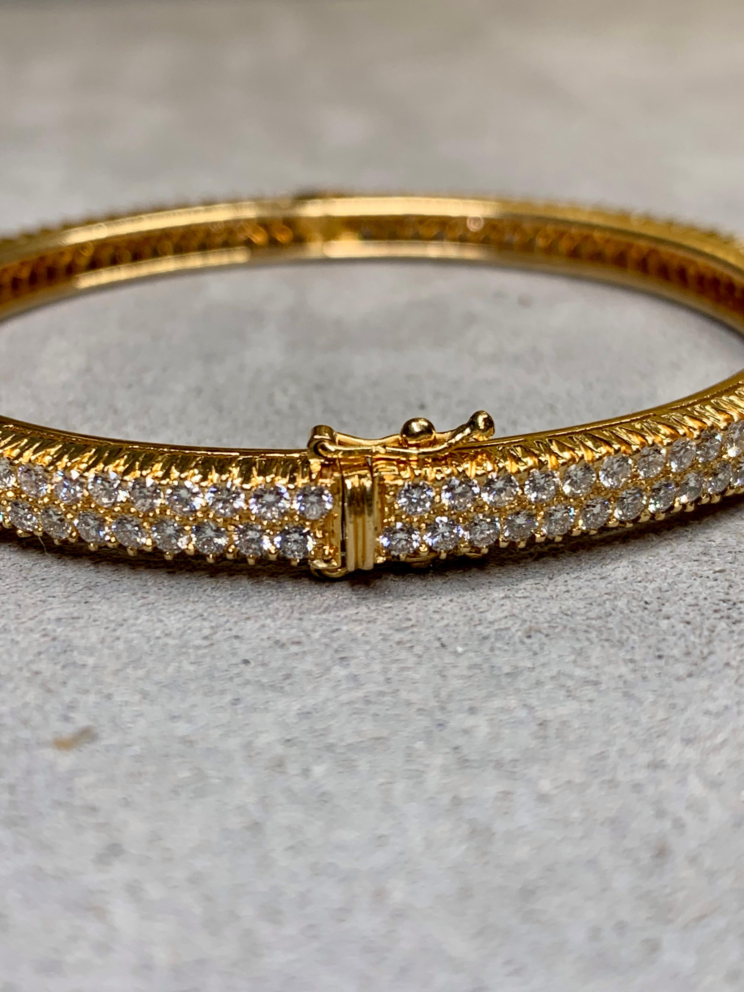 A meticulously hand crafted cuff bracelet done in deep 18K yellow gold and shared-prong set with approximately 5.50ctw in perfectly cut and matched round diamonds averaging F-G color and Vs1-2 clarity. Its quality is exemplary down to even the
