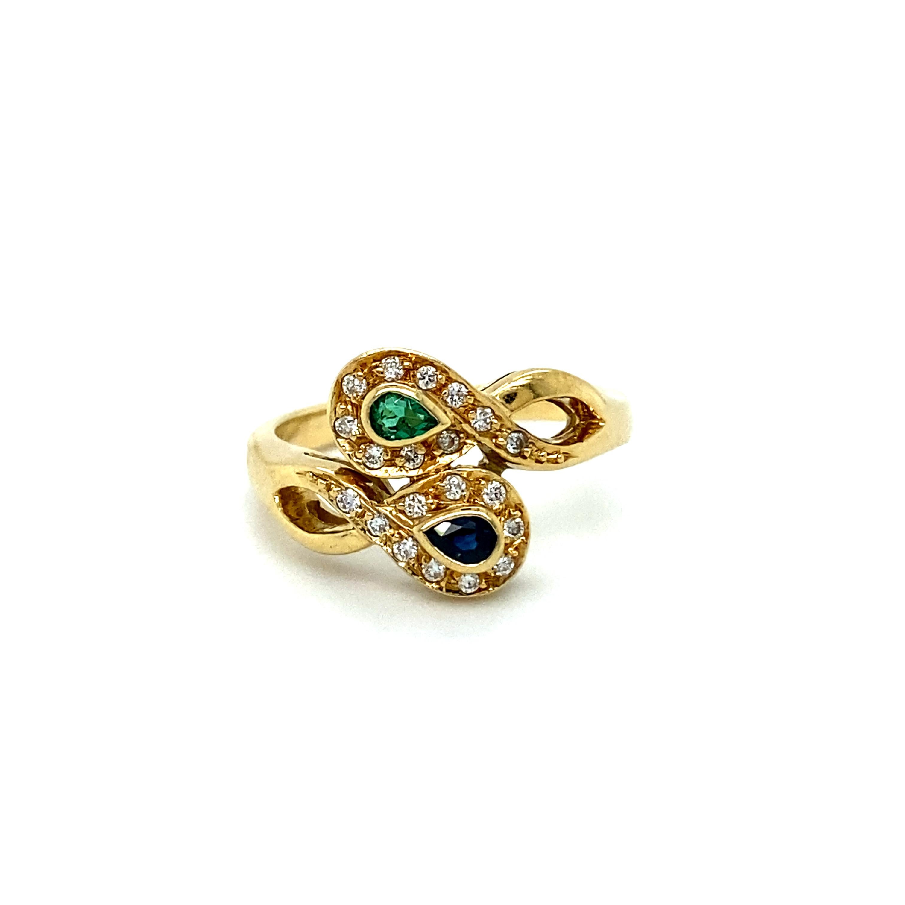 This gorgeous Vintage Emerald, Sapphire, and Diamond Ring truly is a special piece, made by a special maker - H. Stern! Crafted in 18K Yellow Gold, the design is a lovely swirly by pass design, with a Pear Cut Emerald and Sapphire opposite,