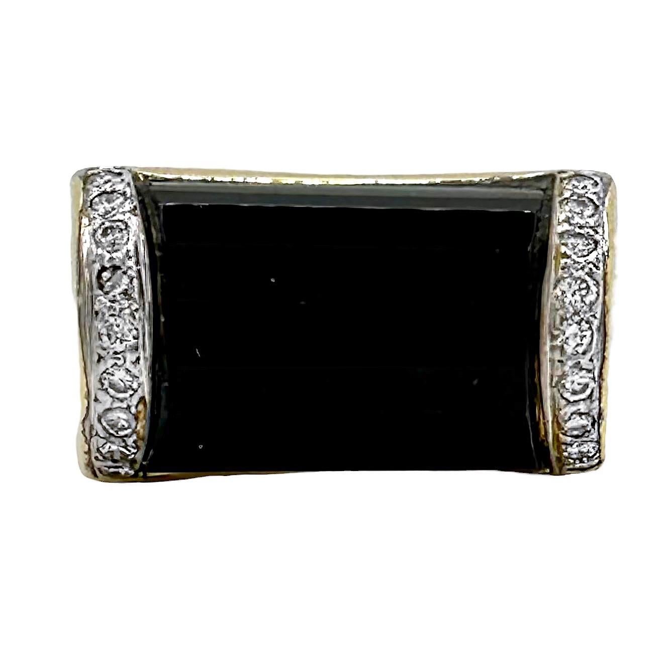 This very nicely fabricated vintage fashion ring, in 18k yellow gold has, as it's focal point one 5/8 inch long faceted black onyx cabochon. Flanking this are a total of eighteen brilliant cut diamonds with a total approximate weight of .25ct and an