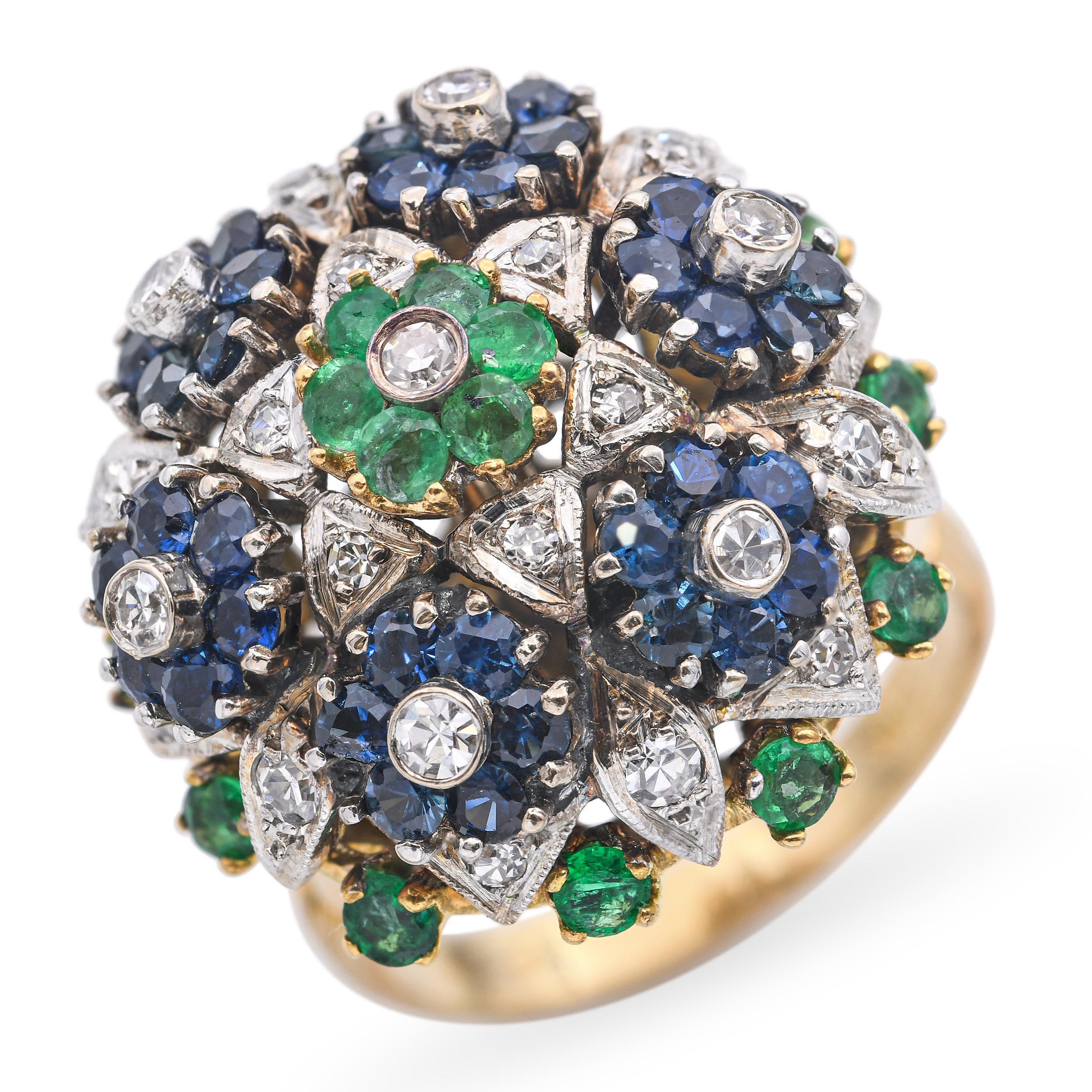 Questo audace e vibrante anello vintage è realizzato in ricco oro giallo 18 carati e sfoggia un dinamico design di ispirazione floreale con 0,60 carati di diamanti scintillanti, 1,08 carati di zaffiri vivaci e 0,54 carati di smeraldi lussureggianti.