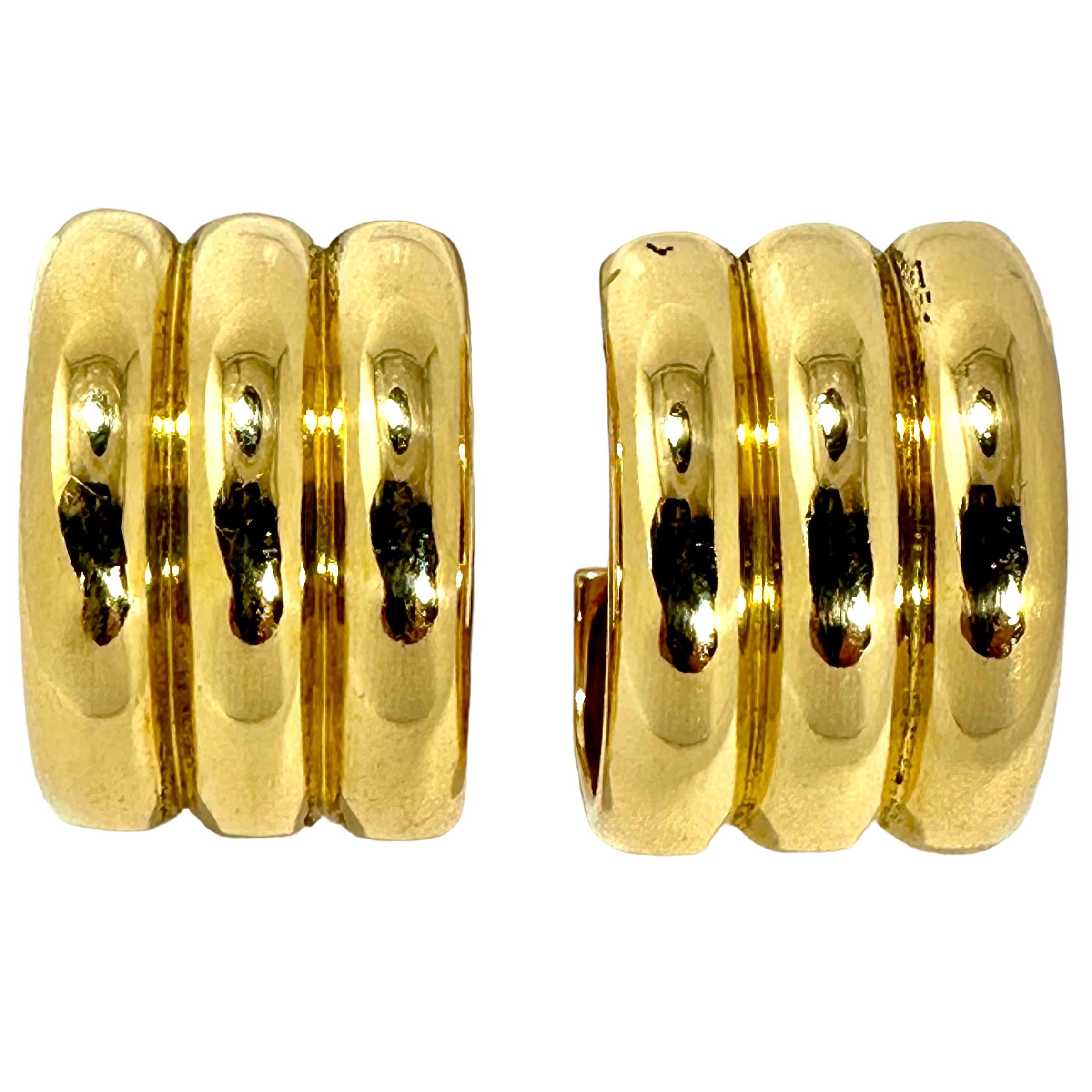 This bold and striking pair of 18k yellow gold French Cartier wide, hoop earrings are designed as three long bombe lines of melon fluted gold. 
This tailored, crisp look is great for everyday wear. With dimensions of 1 inch in length by a width of