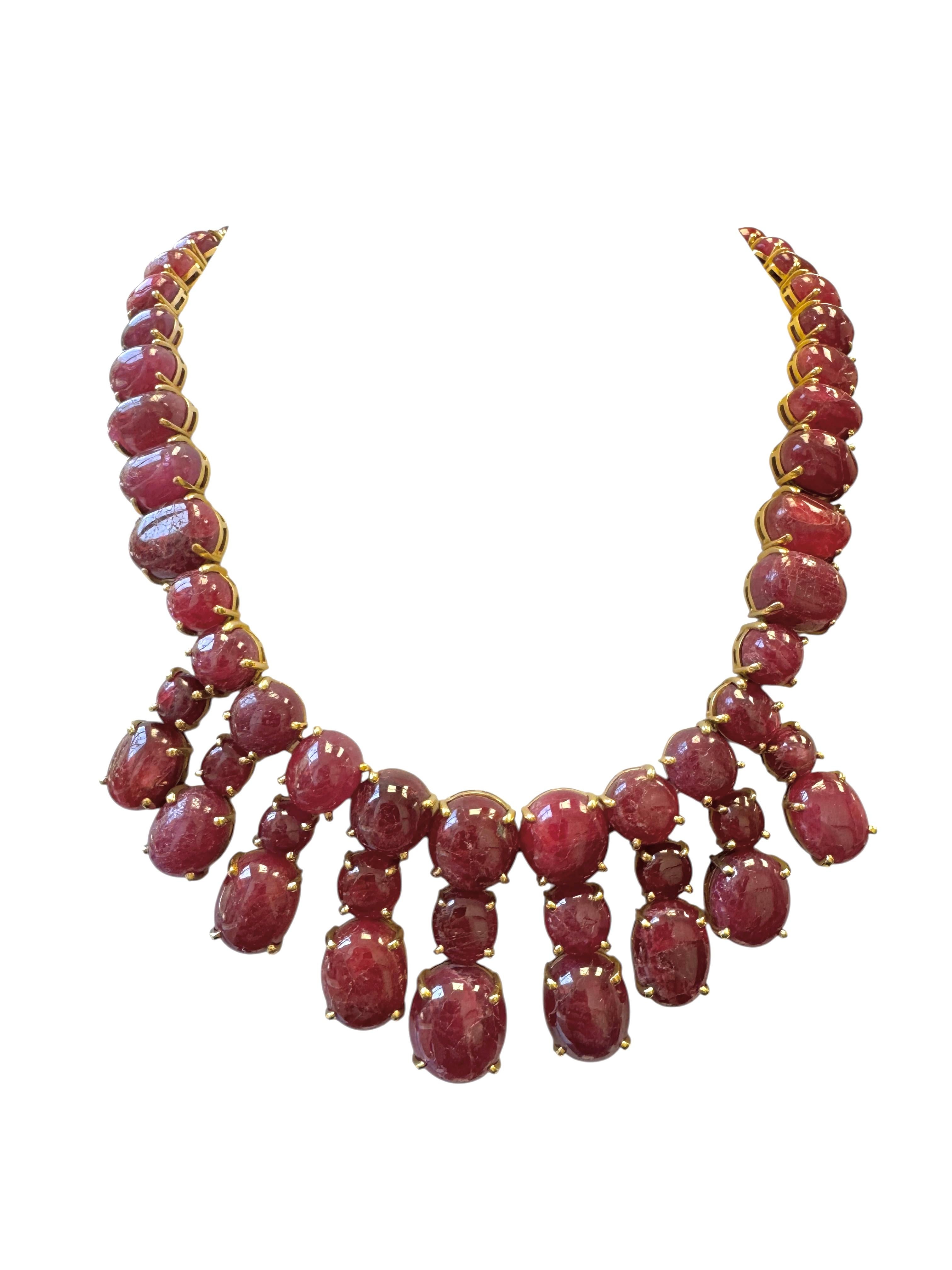 Un magnífico collar vintage elaborado en oro amarillo de 18 quilates, con una sorprendente variedad de rubíes cabujón naturales dispuestos en un espectacular diseño de flecos graduados. El collar exhibe más de 70 rubíes de color rojo púrpura