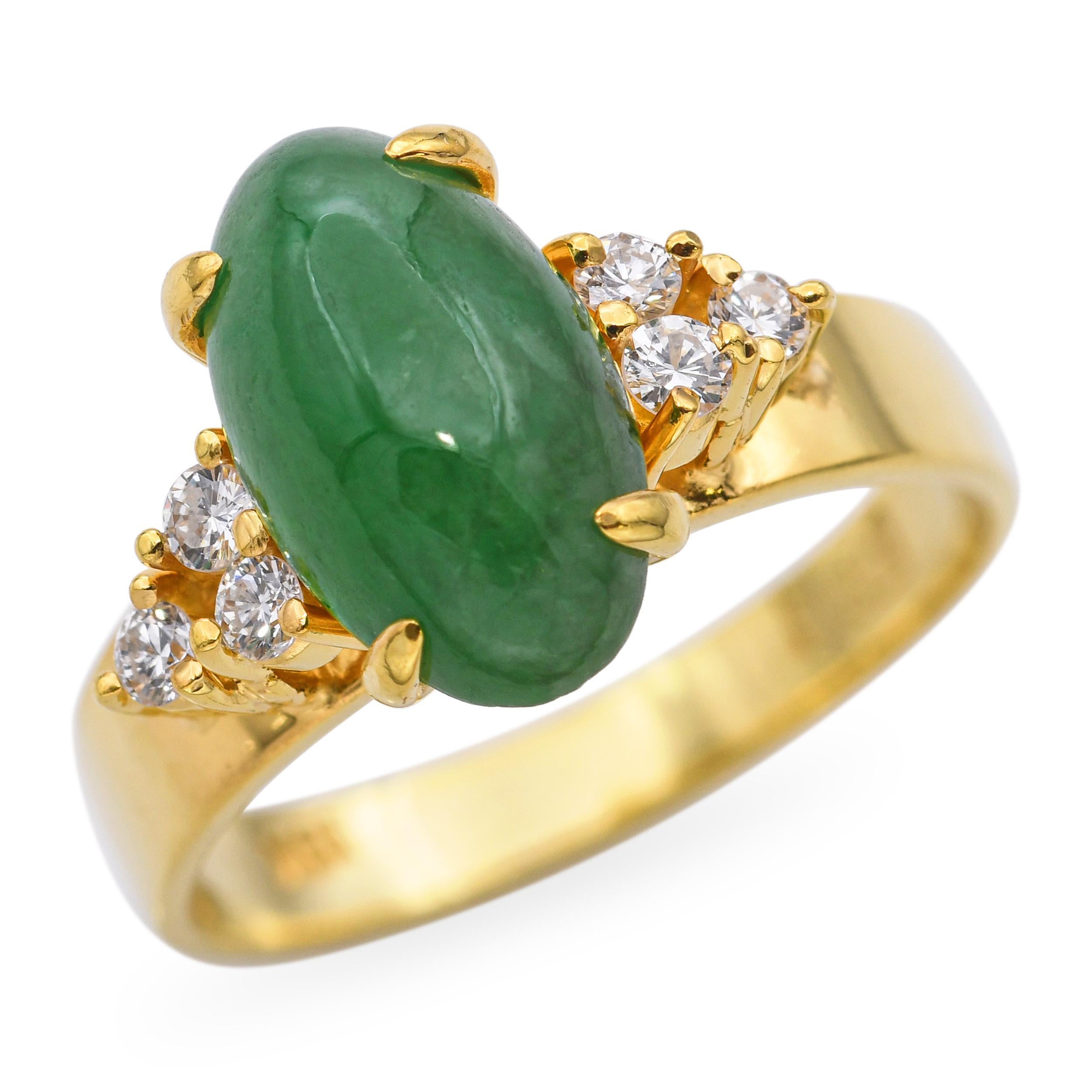 Este elegante anillo vintage está elaborado en oro amarillo de 18 quilates y luce como pieza central un cabujón de jade verde liso y rico en matices. Rodeando al jade hay 0,18 quilates totales de brillantes diamantes, que añaden un refinado toque de