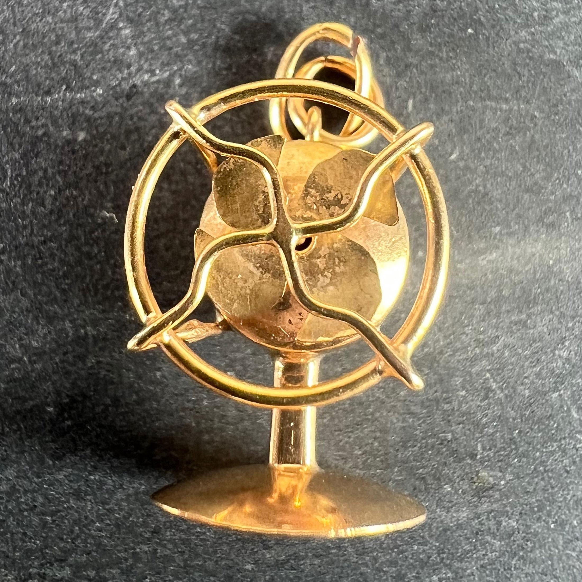 A vintage 18 karat (18K) yellow gold charm pendant designed as a mechanical desk fan with rotating blades and safety grid. Unmarked but tested for 18 karat gold. 

Dimensions: 1.8 x 1.2 x 1 cm
Weight: 1.93 grams
(Chain not included)