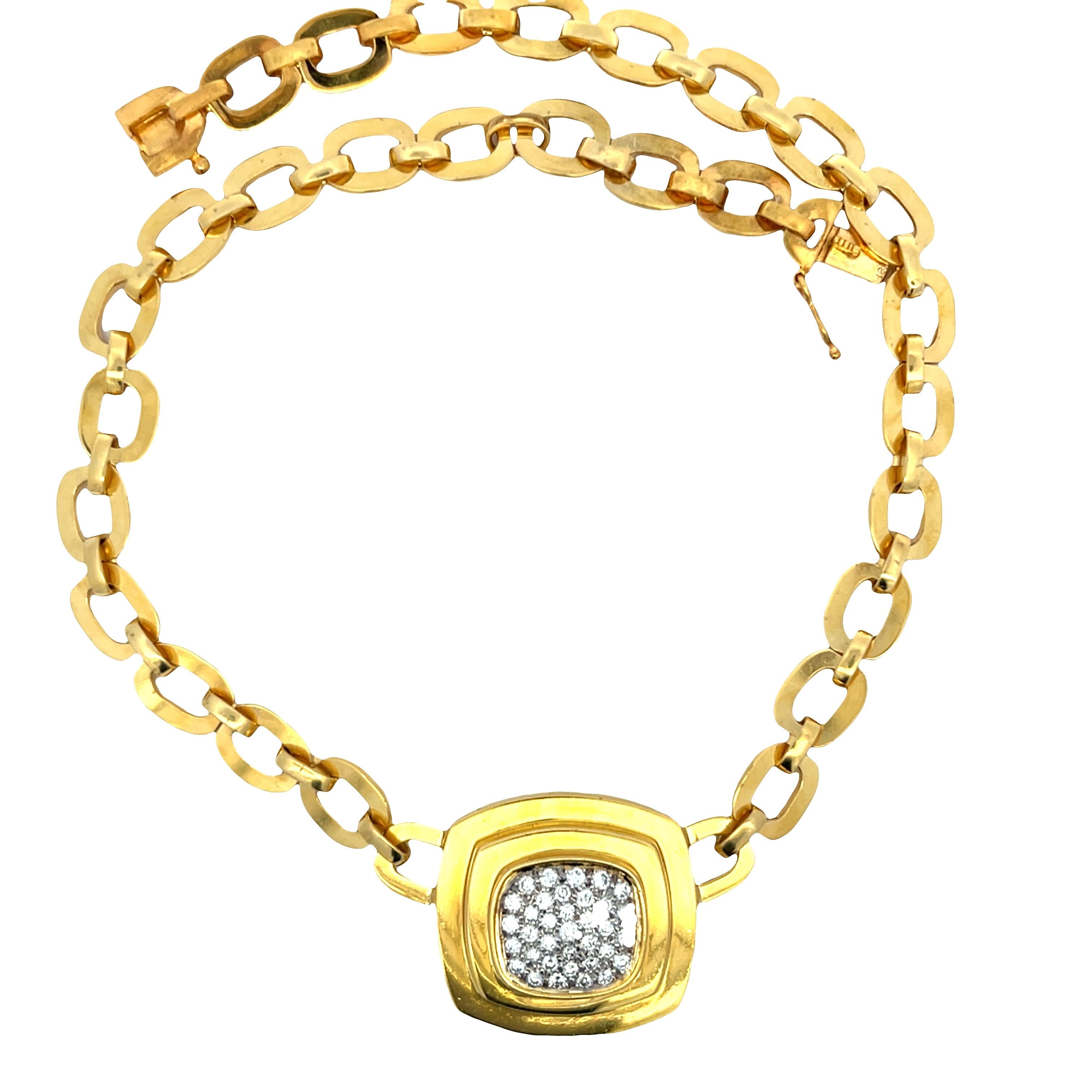 This vintage necklace is a striking example of sculptural luxury, crafted in 18K yellow gold with a confident, timeless presence. It features a substantial chain of oval links that leads to a central cushion-shaped pendant, designed with soft curves
