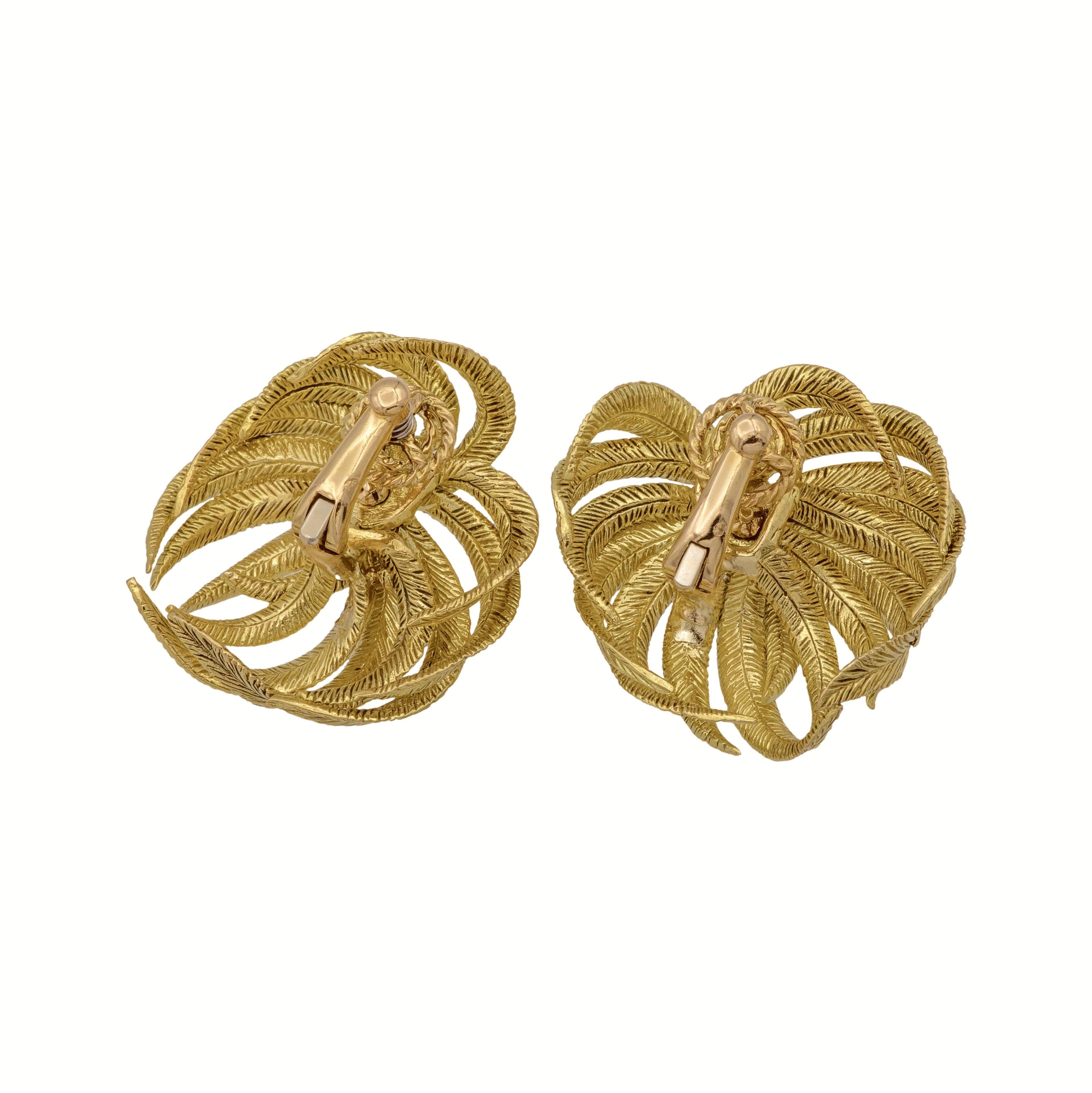 This pair of vintage ear-clips, dating back to the 1950s, is finely crafted in 18K yellow gold and features an elegant palm leaf motif. Made by a French master craftsman, these earrings reflect meticulous attention to detail and superior quality.