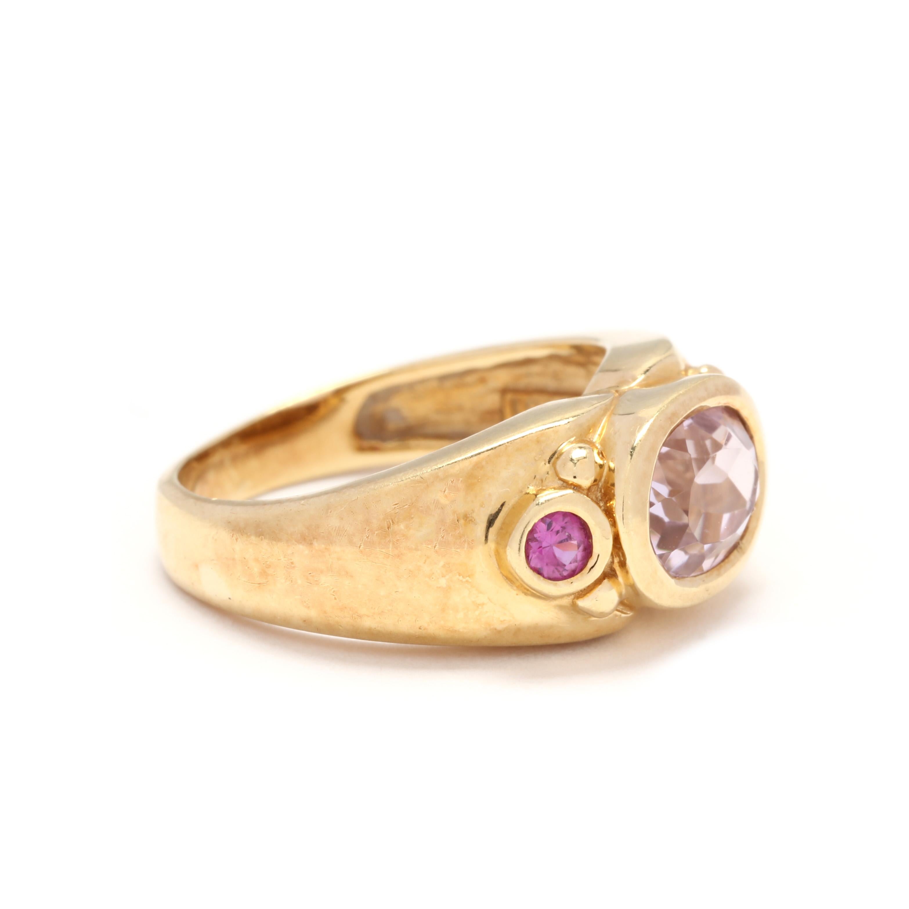 A vintage 18 karat yellow gold, pink topaz and pink sapphire ring. A wide tapered band centered on a horizontal, bezel set oval cut pink topaz weighing approximately 2.40 carats with a bezel set, round cut pink sapphire on either side and with