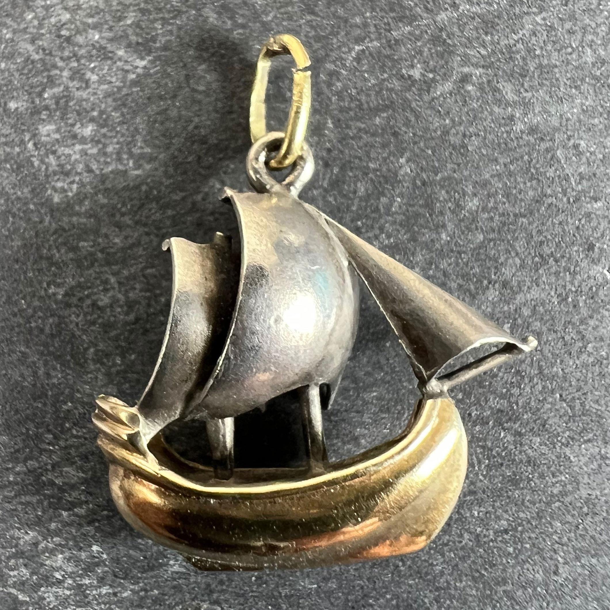 Un ciondolo charme in oro giallo e platino 18 carati (18K) disegnato come uno yacht o una barca a vela con uno scafo in oro giallo e tre vele in platino. Non segnato ma testato per oro 18 carati e platino.

Dimensioni: 1,6 x 1,6 x 0,5 cm (escluso